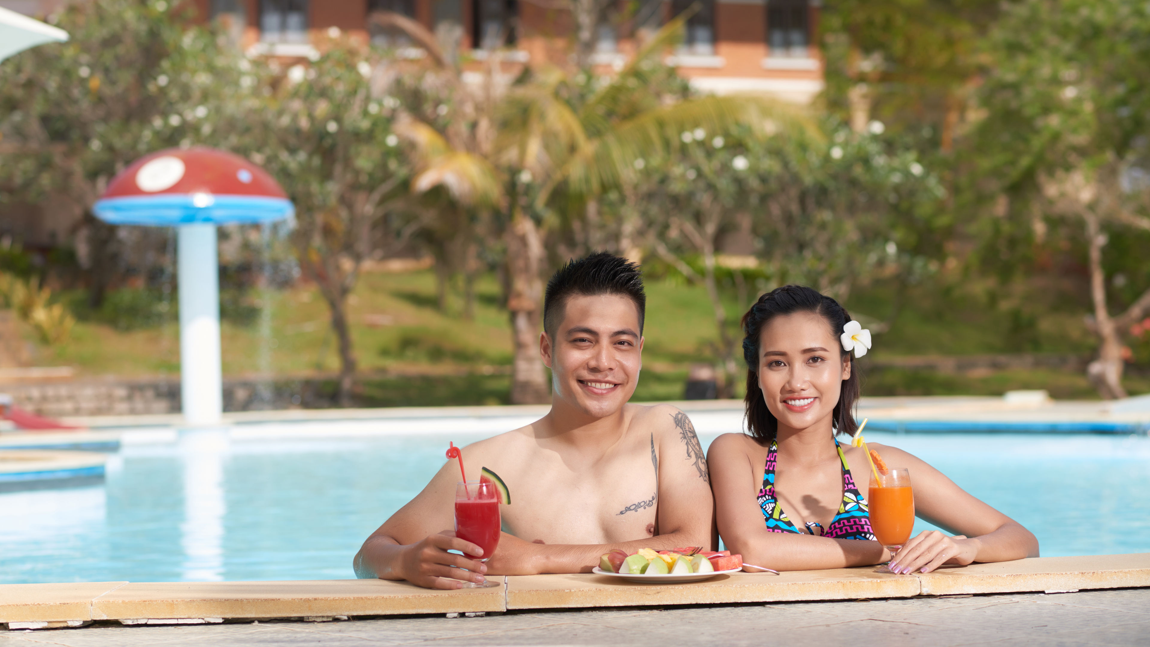 Couple Enjoying Tropical Drinks in Swimming Pool