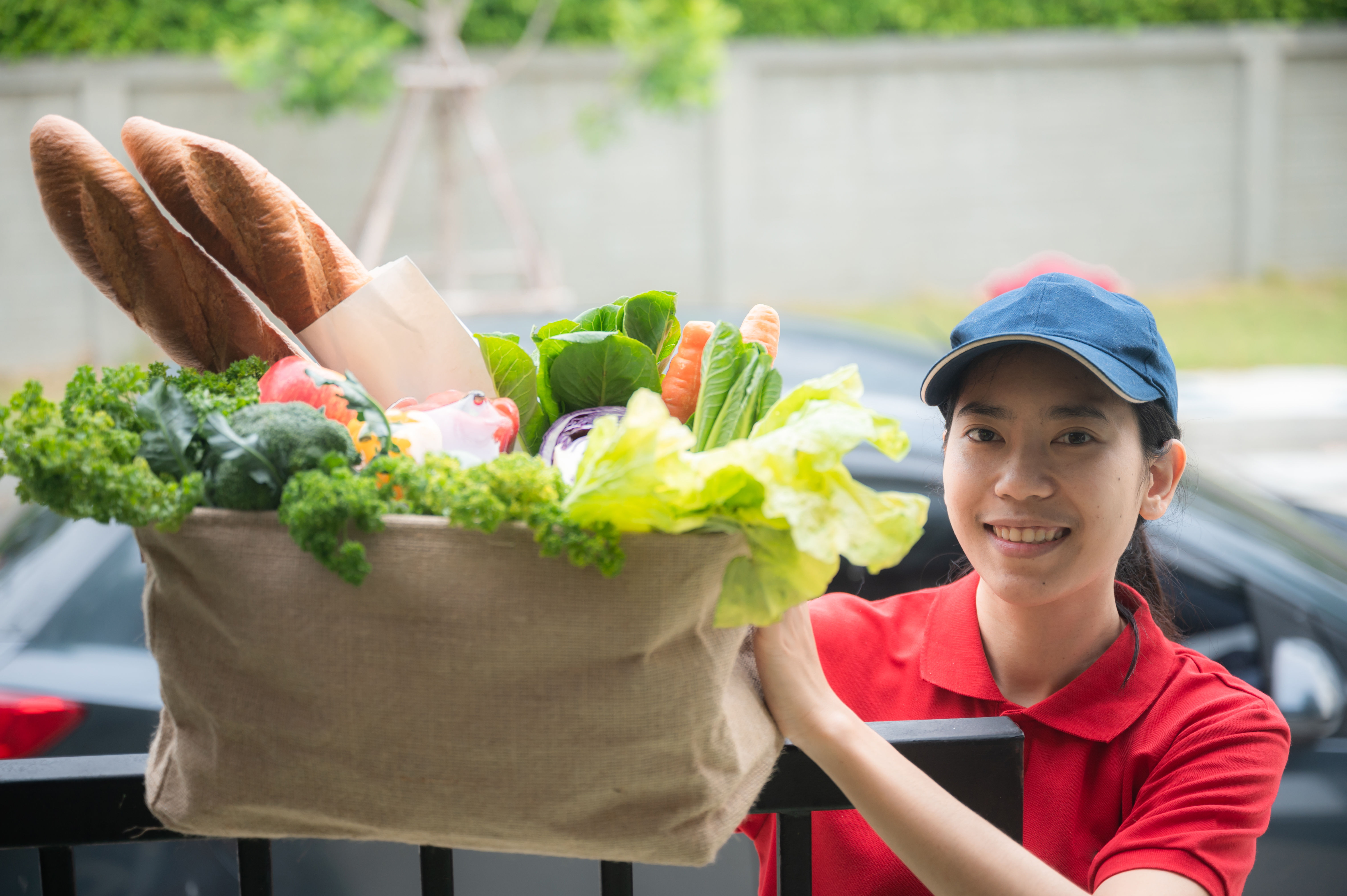 Isang delivery woman na may hawak na ilang groceries
