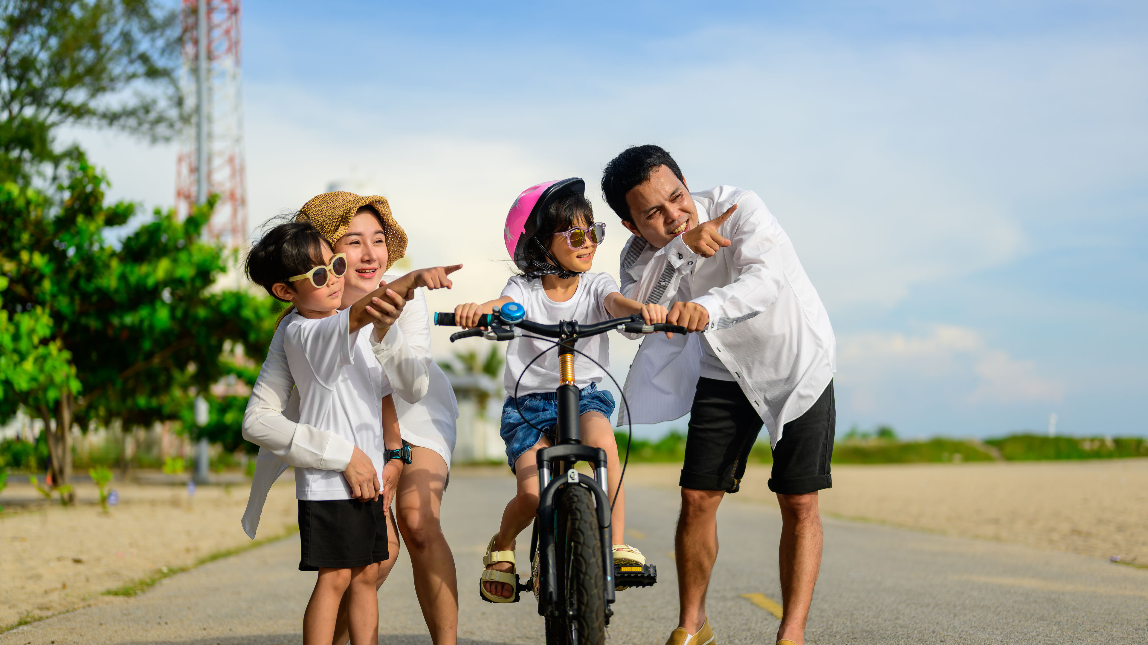 A family spending time with their child on a bicycle. 