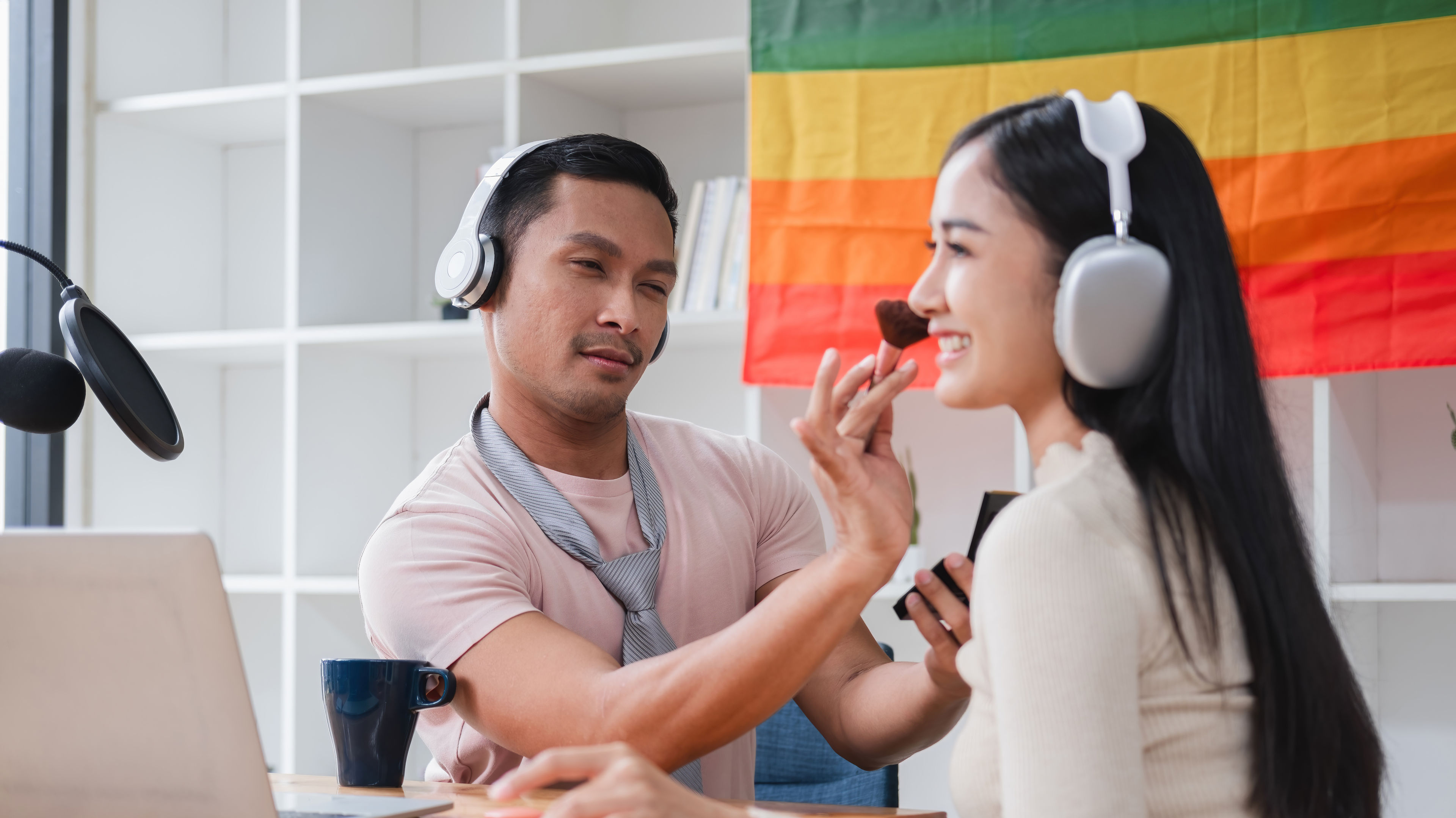 A young man and his girlfriend use a laptop and a microphone