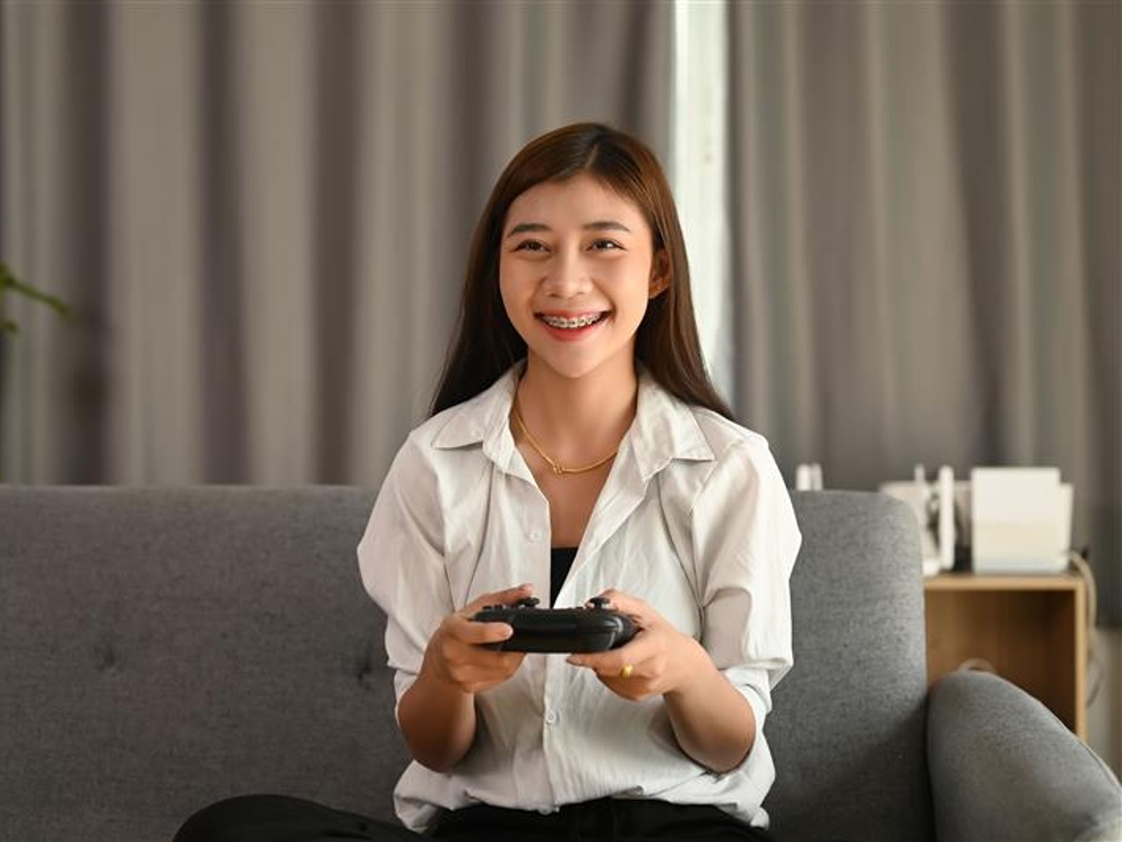 A young woman holding joy stick and playing video games