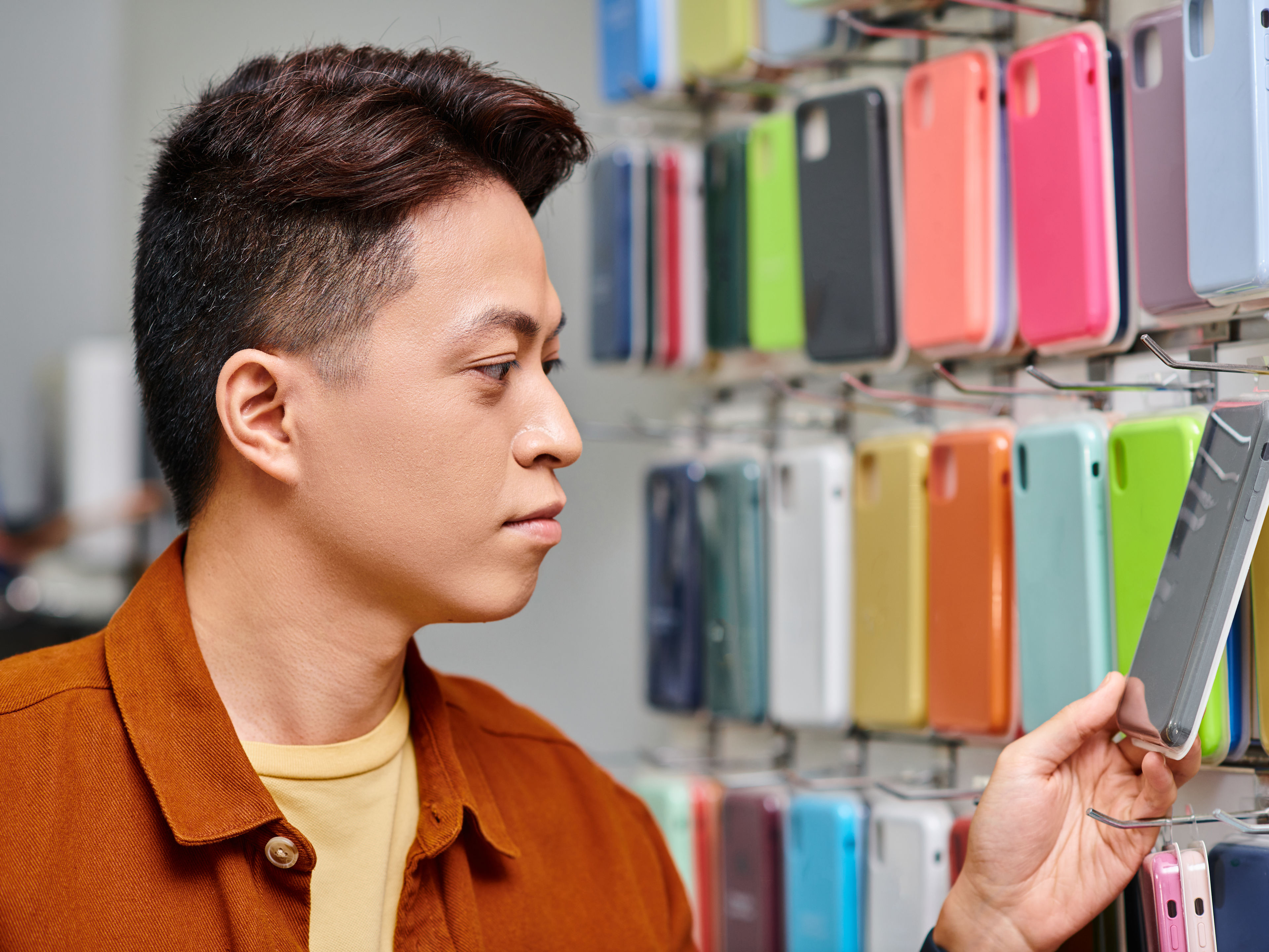 asian entrepreneur looking at colorful phone 