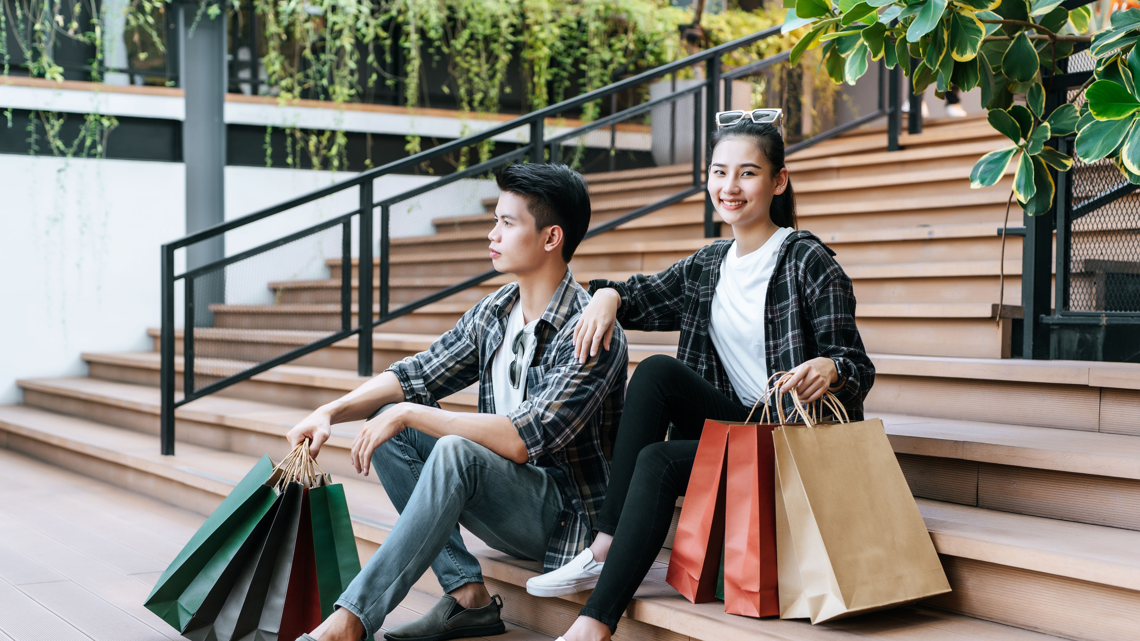 Cheerful Young couple holding multiple paper shopping bag