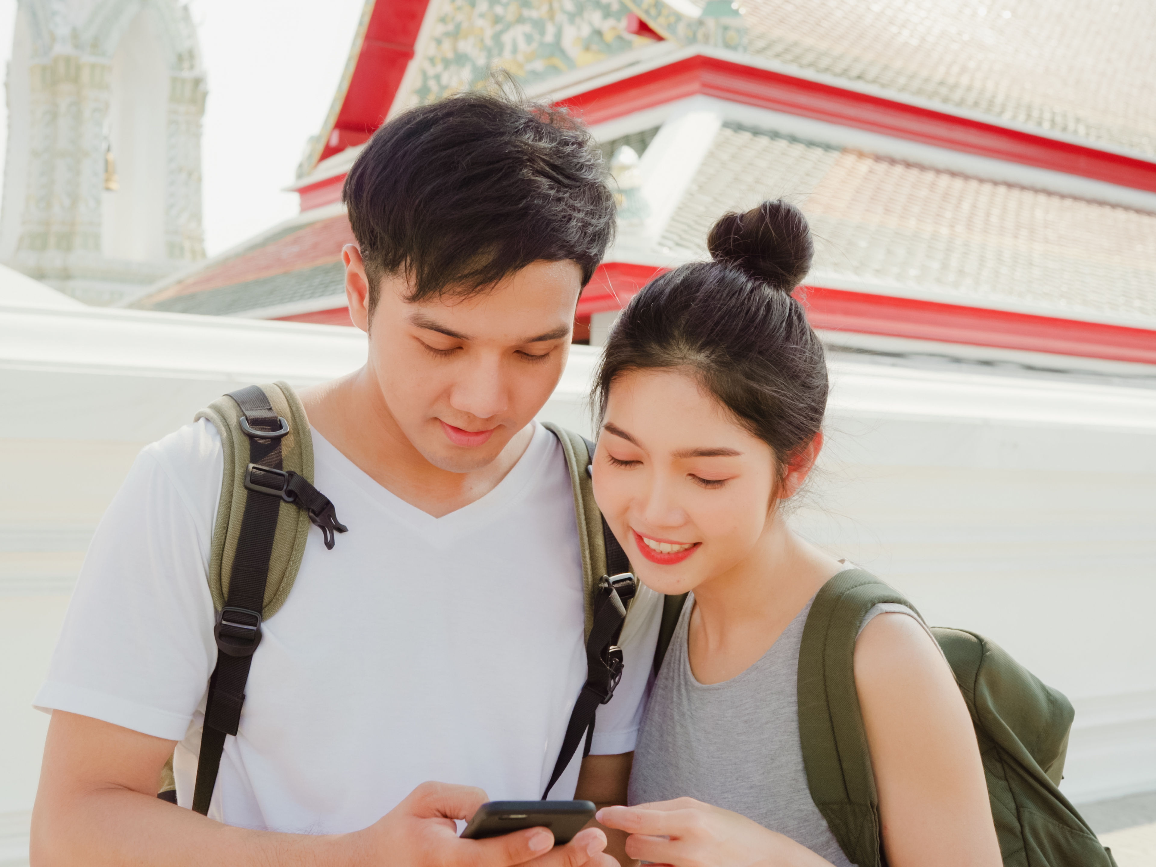 couple using mobile phone looking on map  