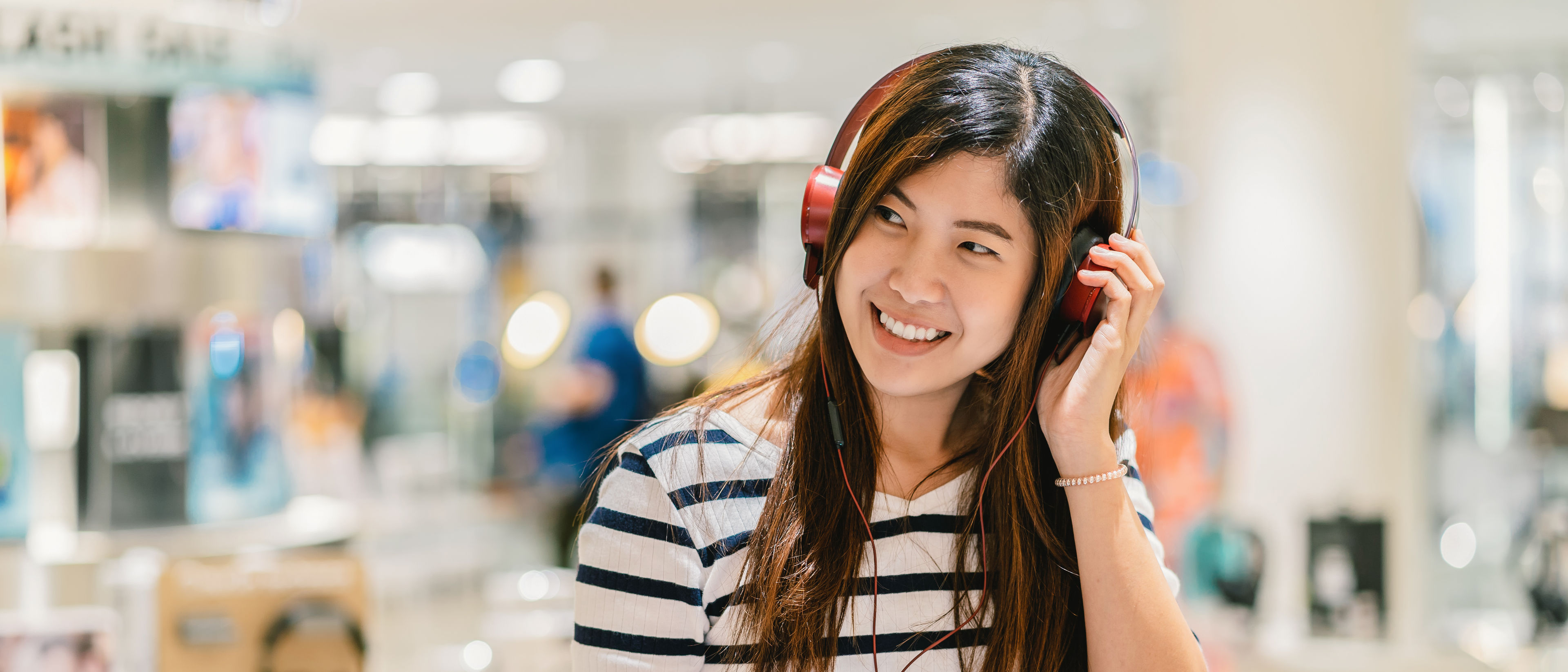 Happy woman testing earphone
