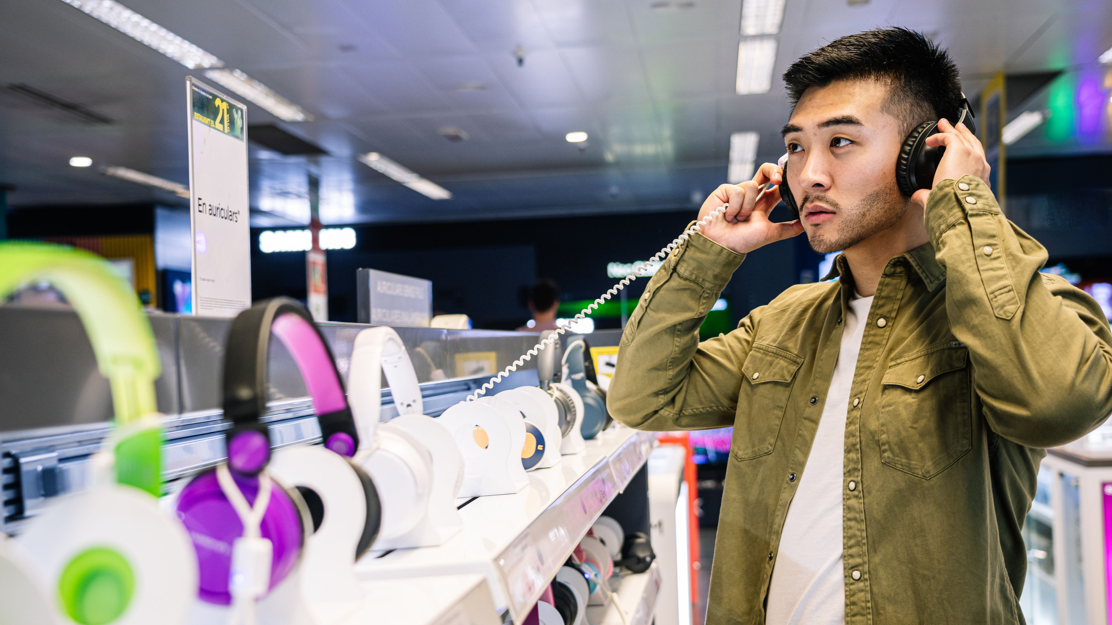 Man Sampling Headphones in Tech Store