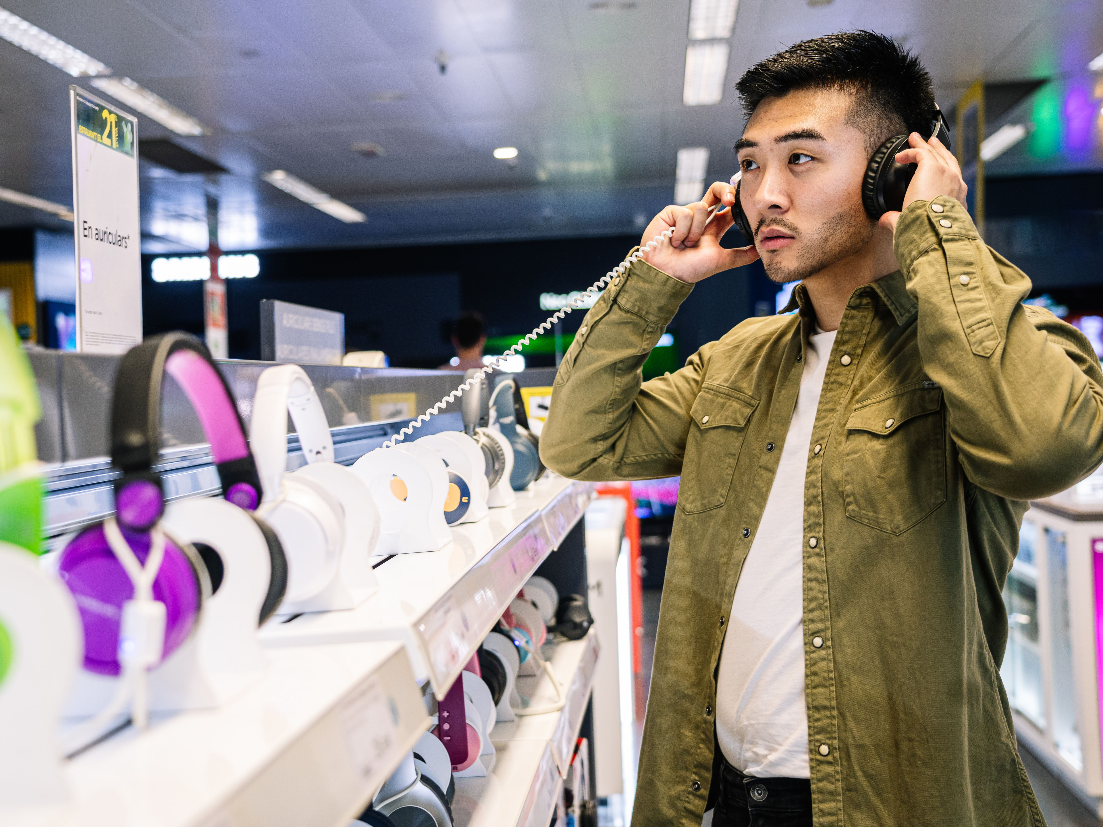 Man Sampling Headphones in Tech Store