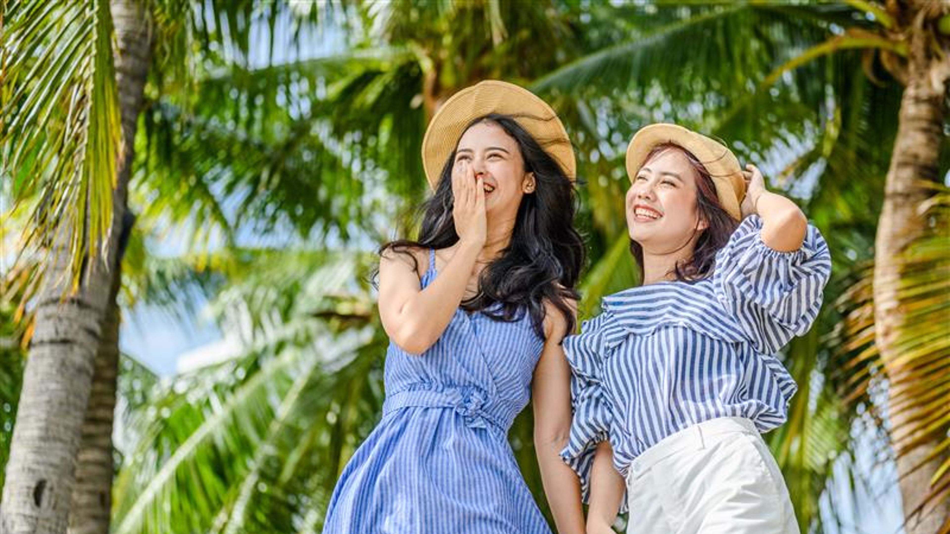 Mga babaeng nakasuot ng sumbrero sa dalampasigan