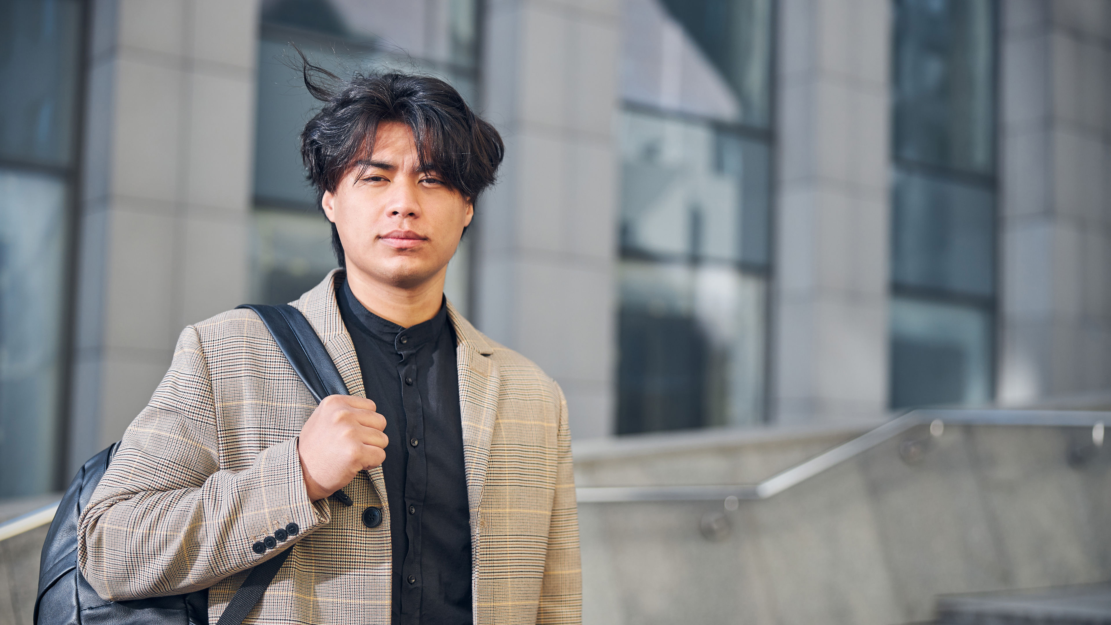 Handsome stylish man with backpack looking at camera