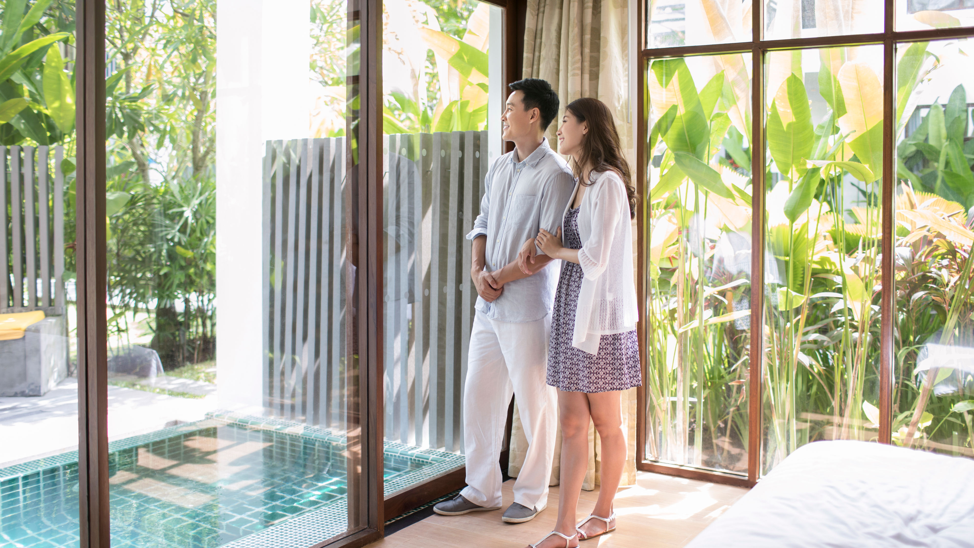 Happy young Chinese couple in hotel room