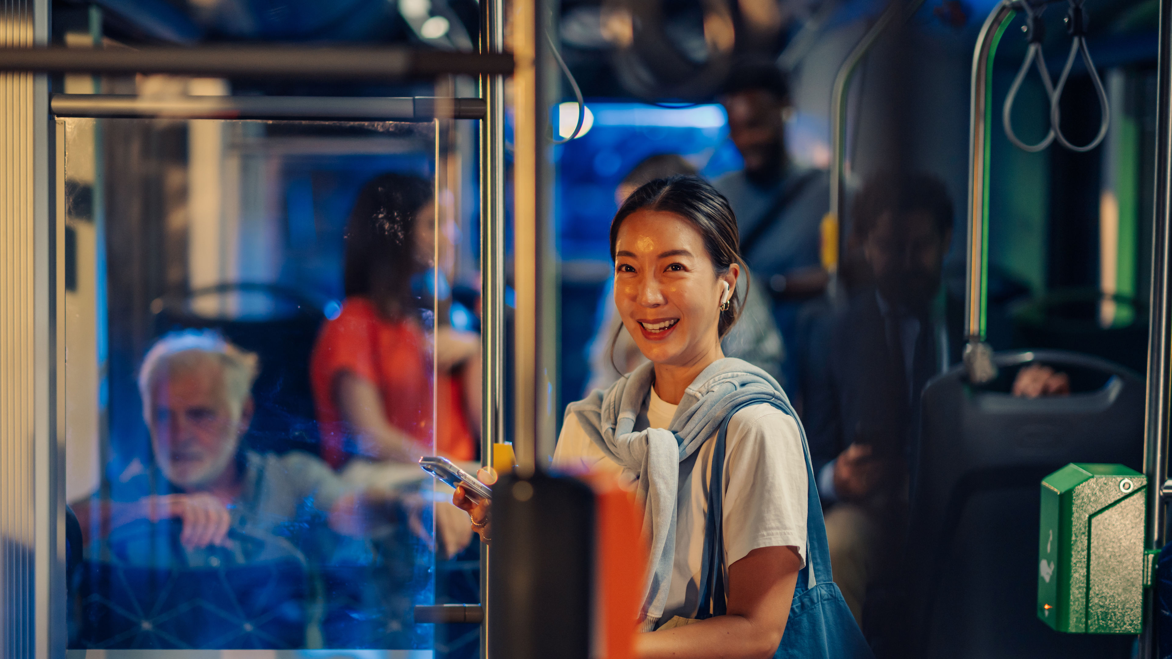 Young woman using smartphone on a modern bus at night