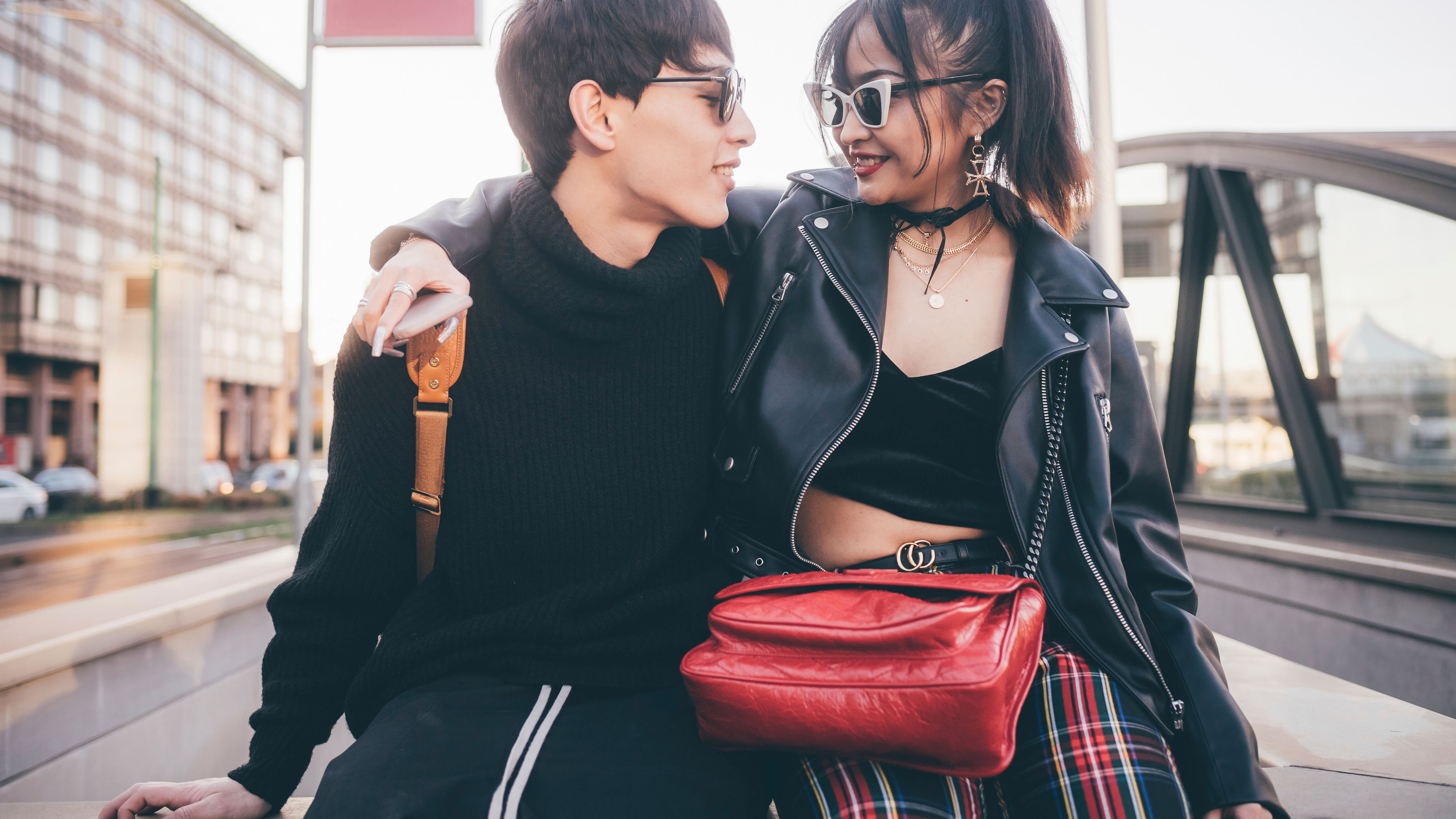 A trendy young couple sits outside.