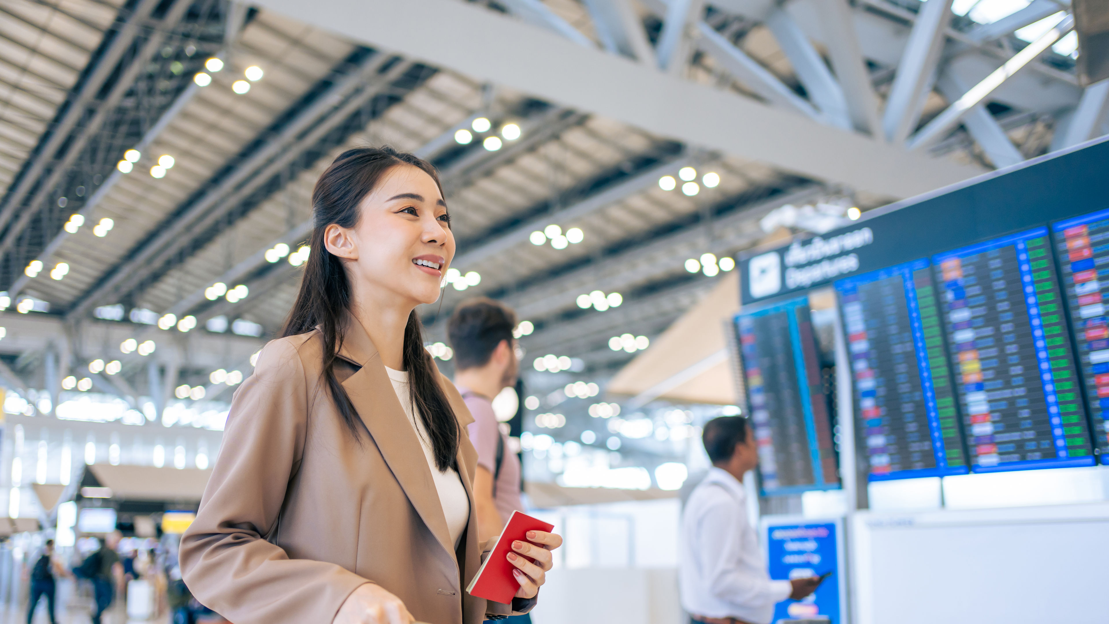 Asian young woman passenger checking depature boarding pass in airport.
