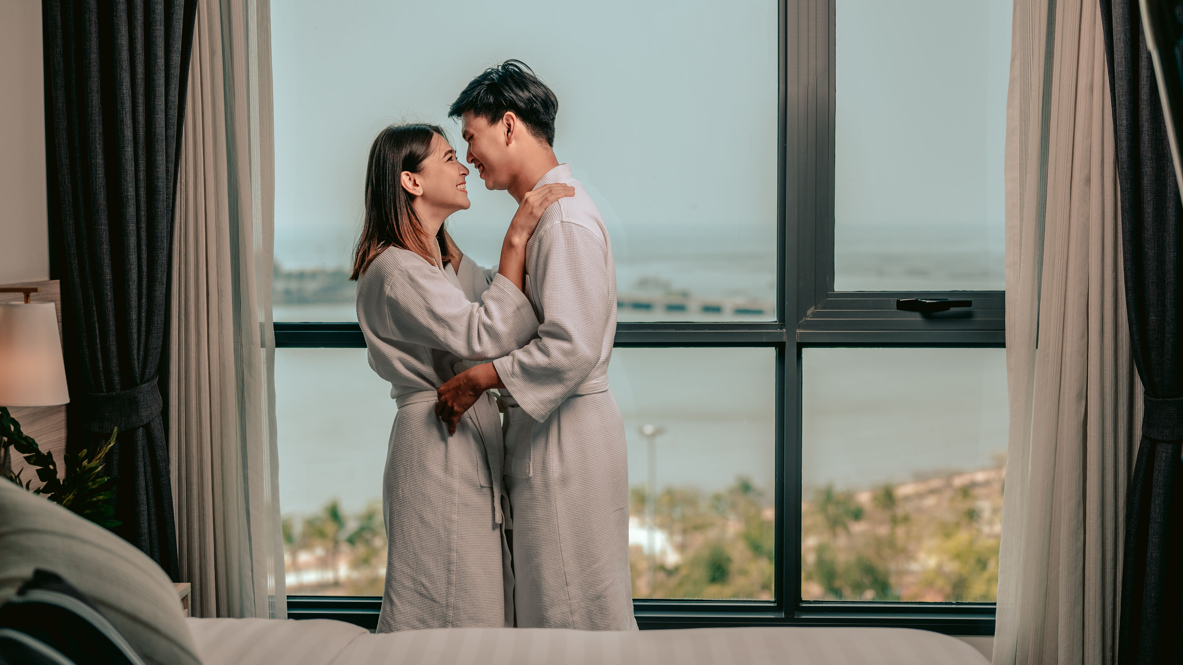 Happy couple standing near window
