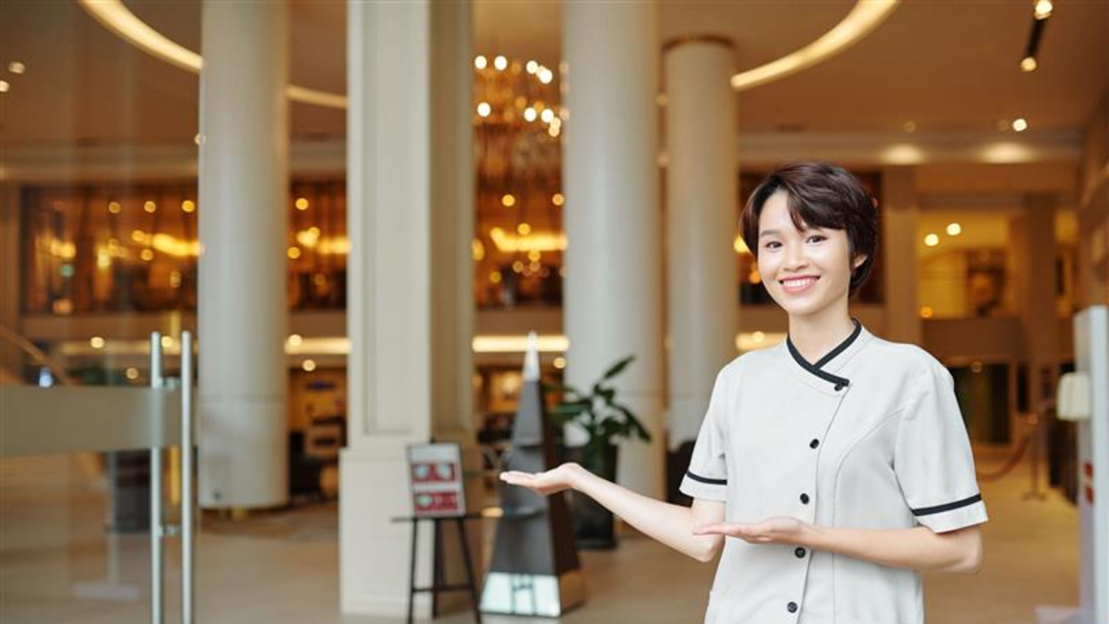Smiling hotel staff member standing in the lobby