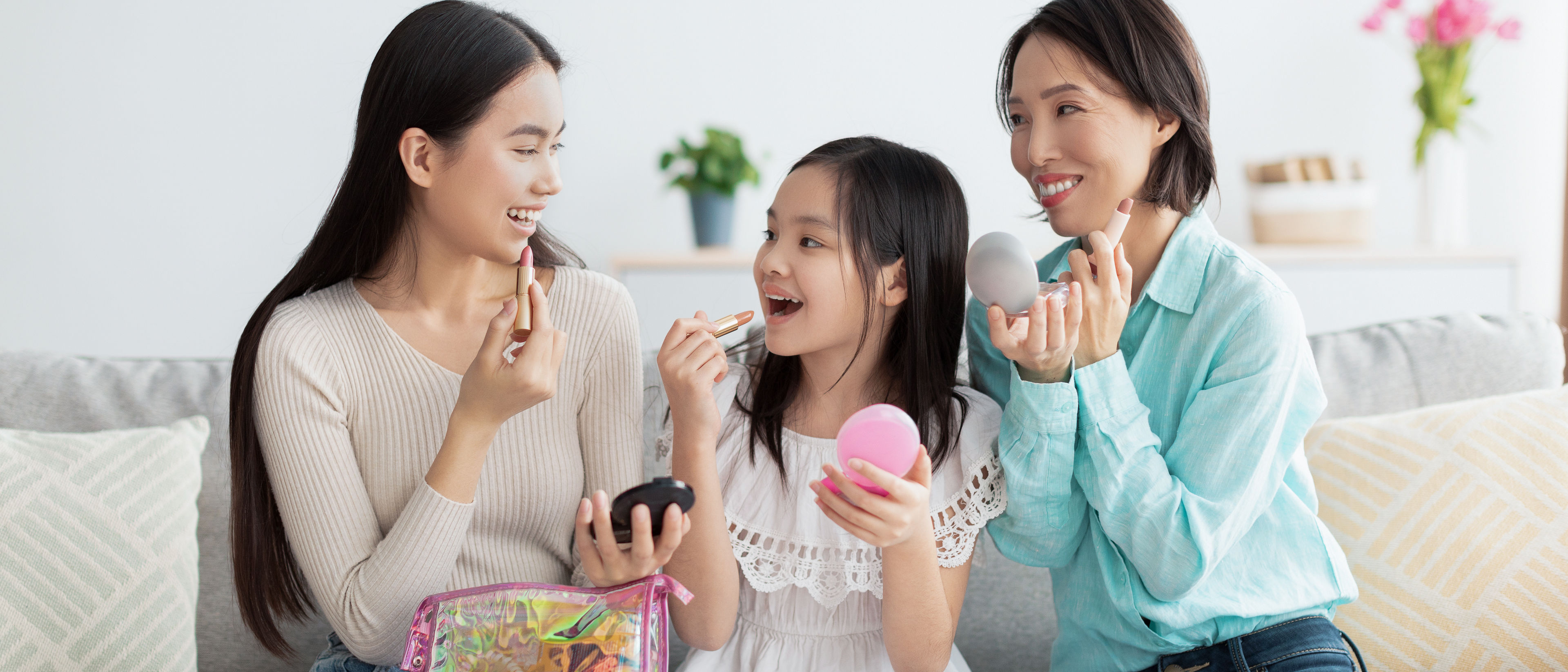 A little girl and two women doing makeup together.