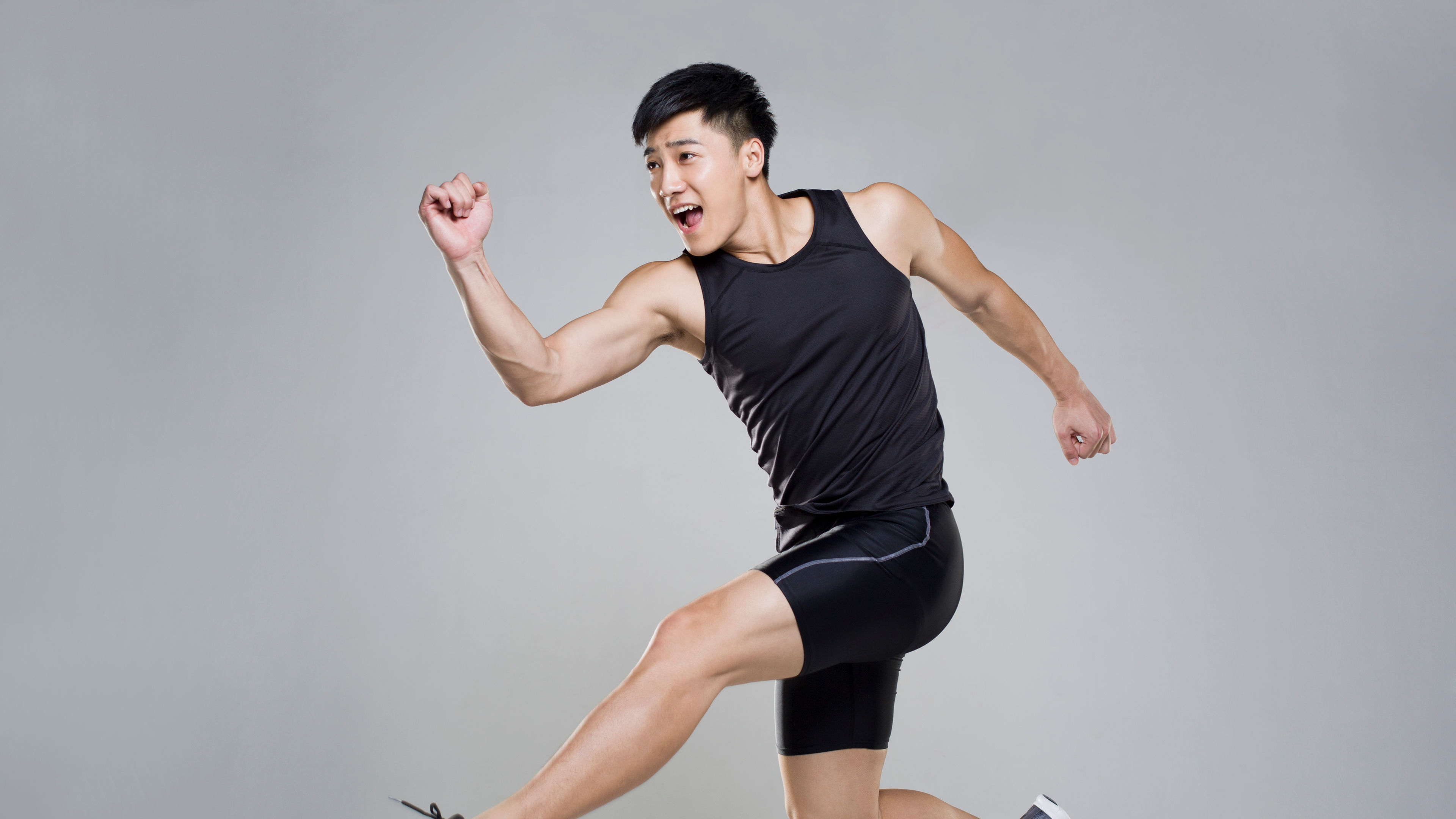 A sports man in black apparel and shoes is running