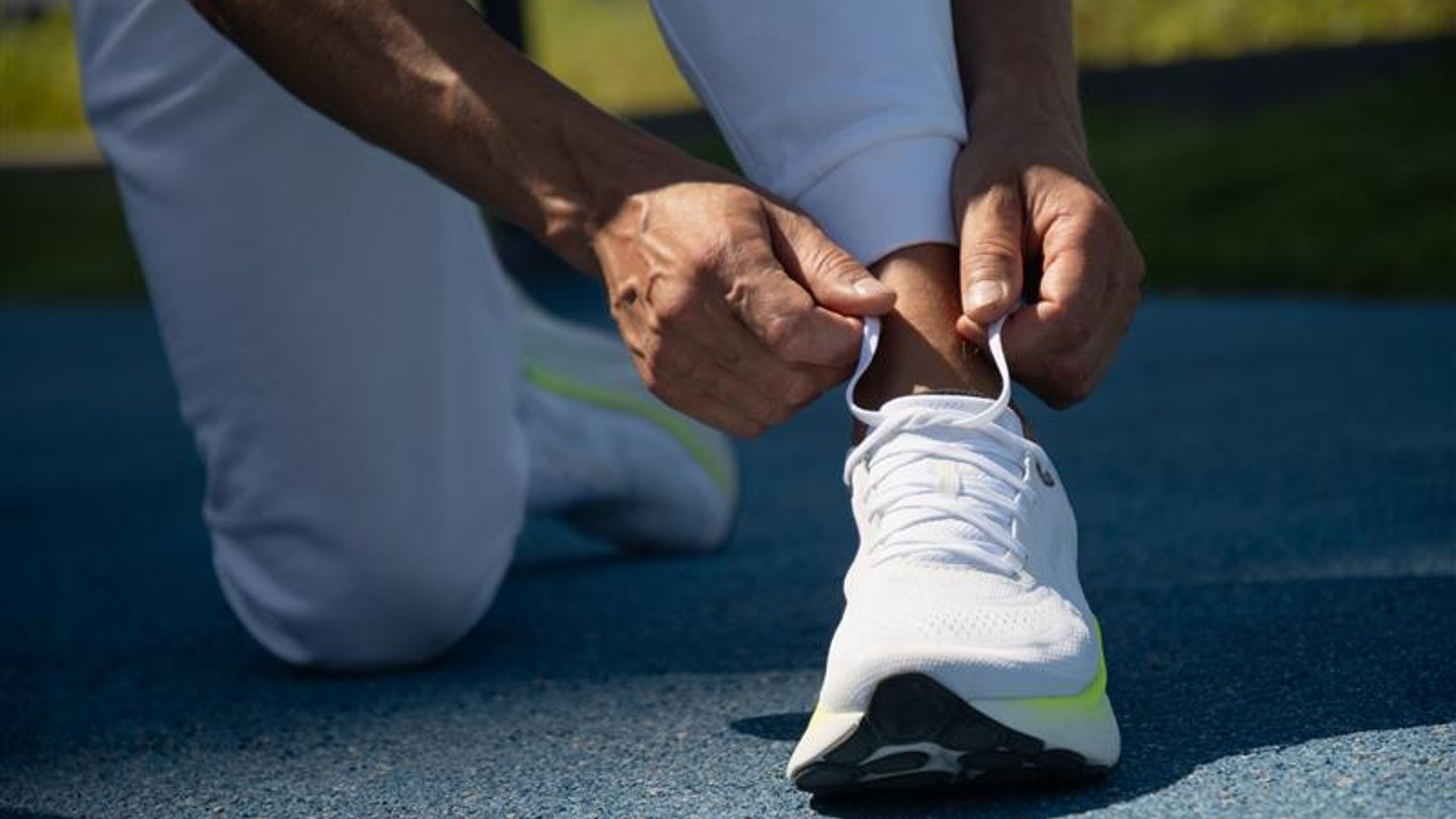 Athletes preparing to workout. Last prep before run. Man athlete tying running shoes shoelace before training 