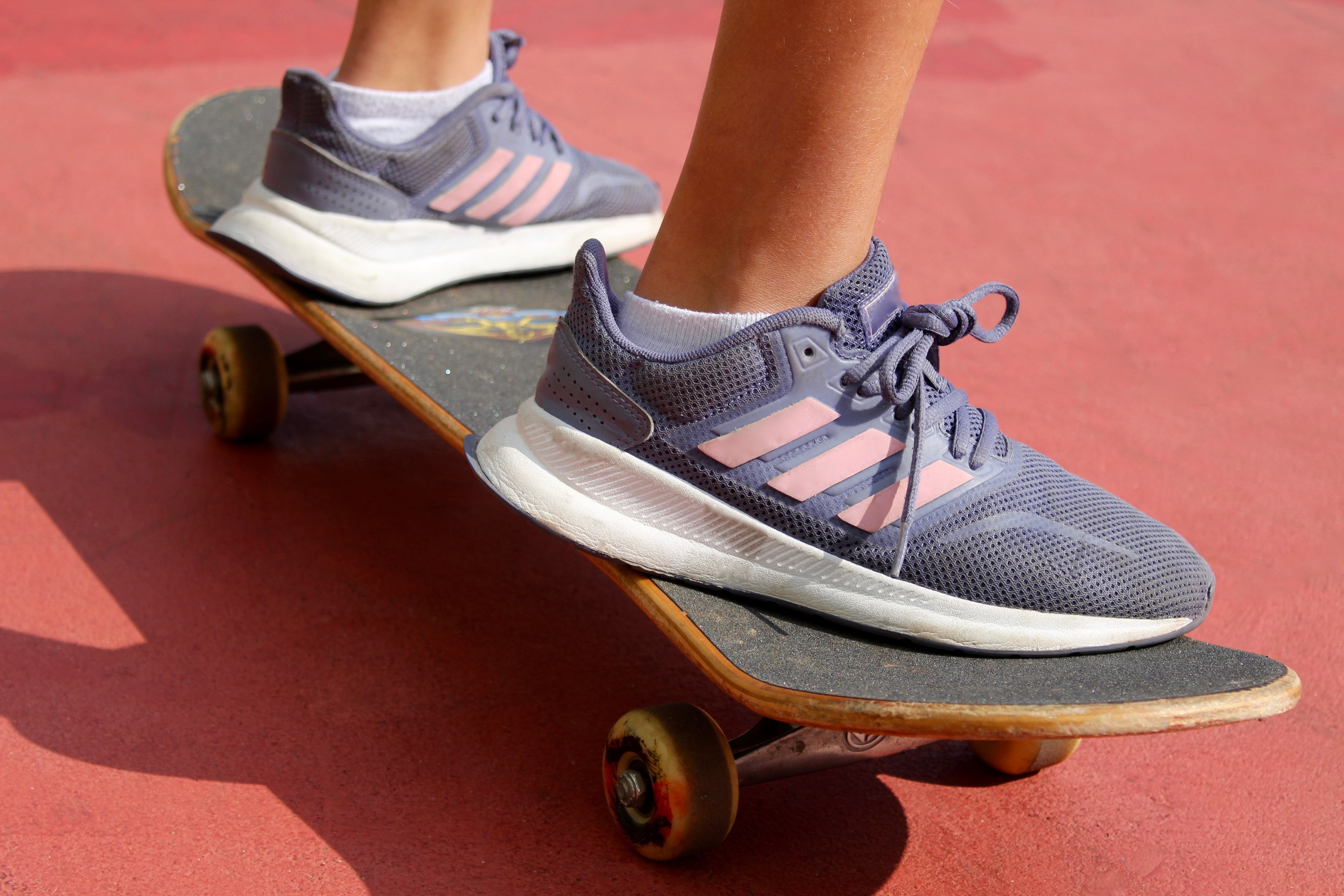 A young woman gracefully glides on her skateboard, balancing with ease and confidence as she carves through the streets. 