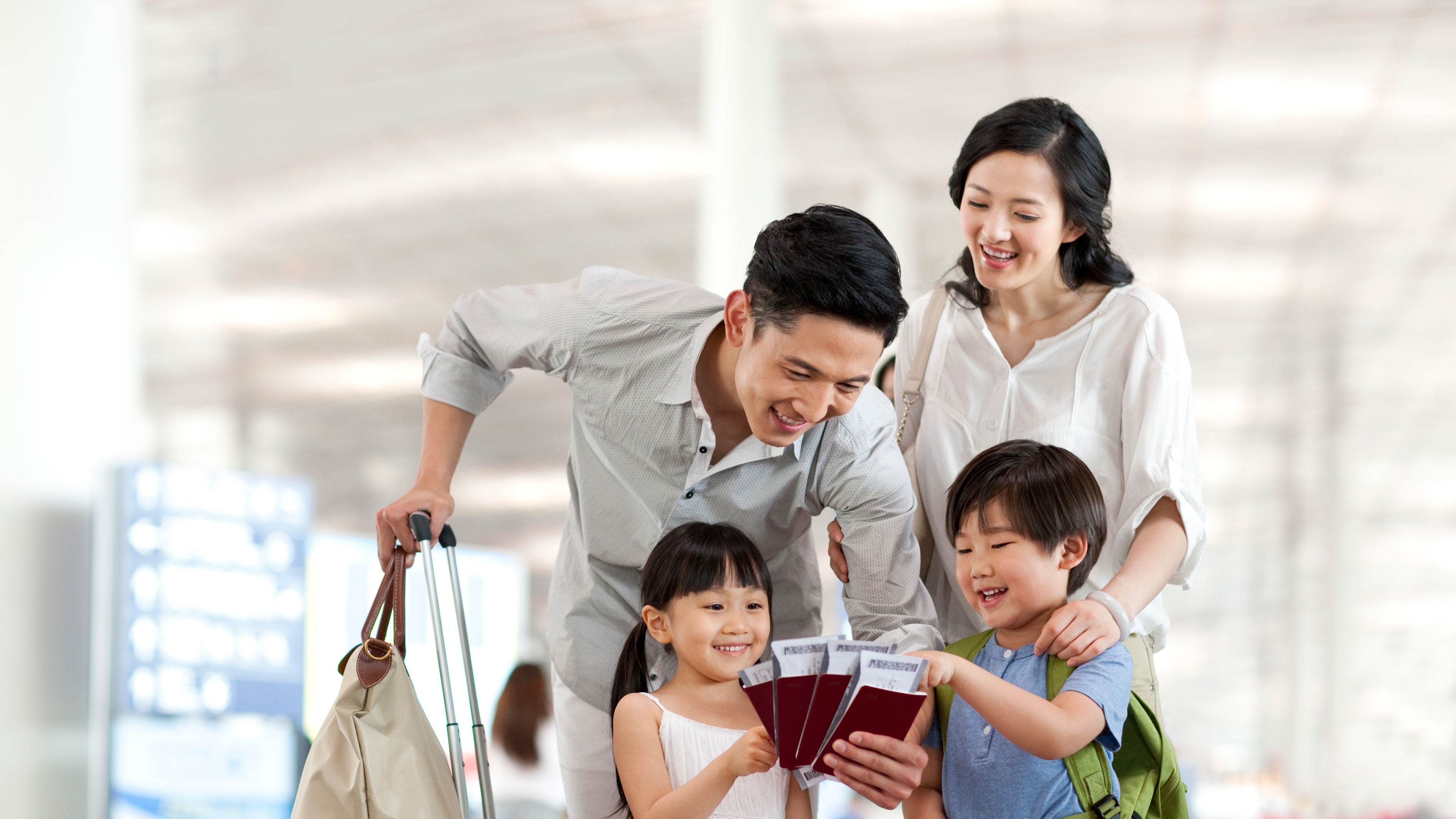 Happy young family with flight tickets and passports at the airport 