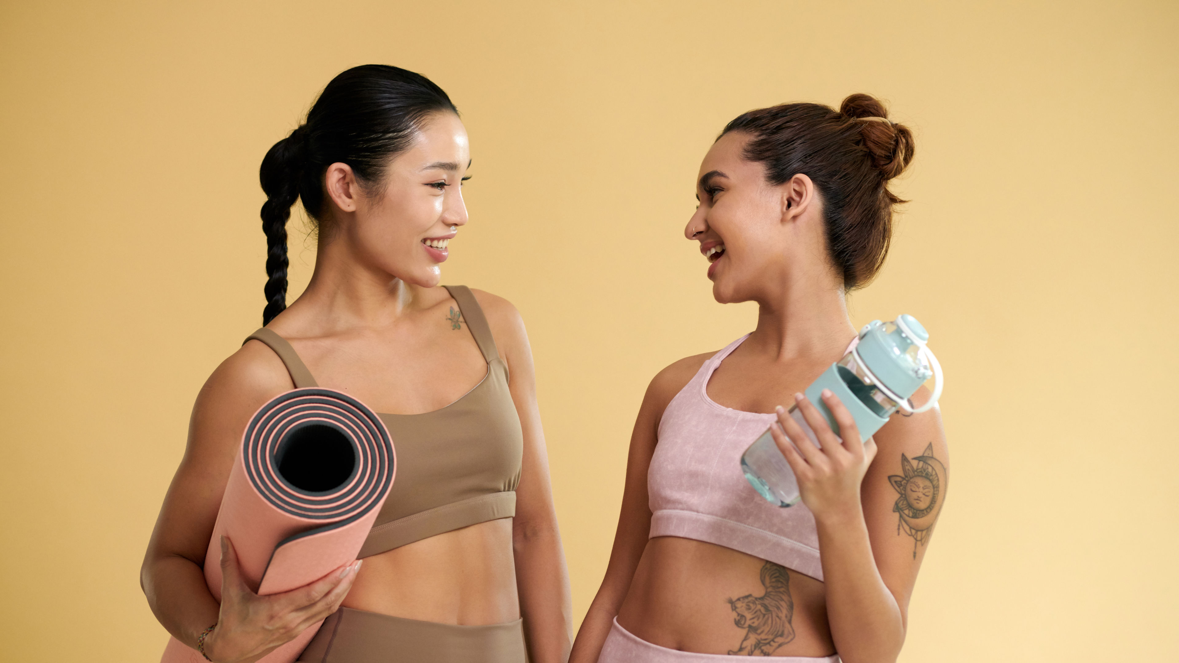 Studio portrait of smiling fit young women looking at each other