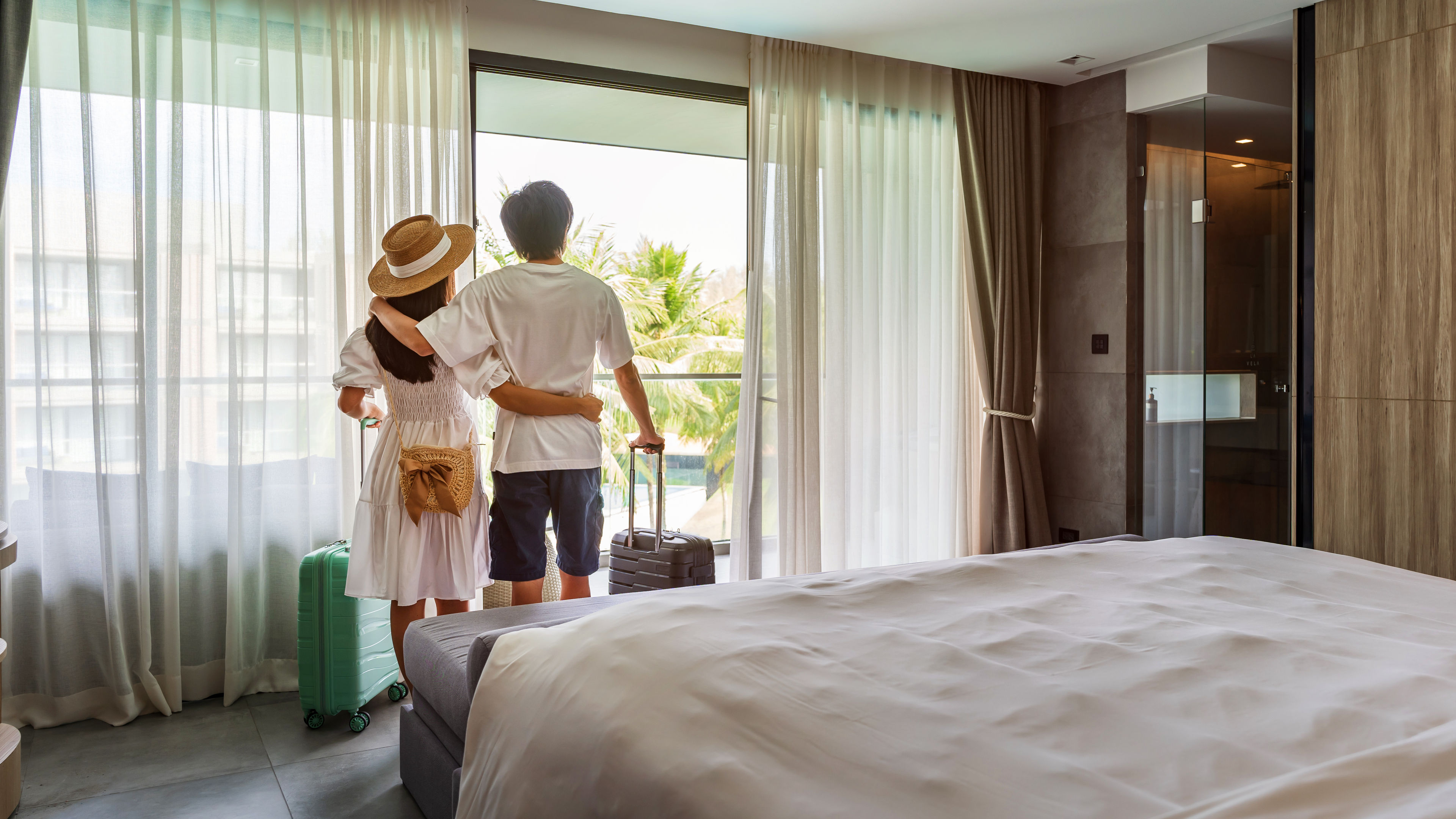Young couple of travellers opening the curtains