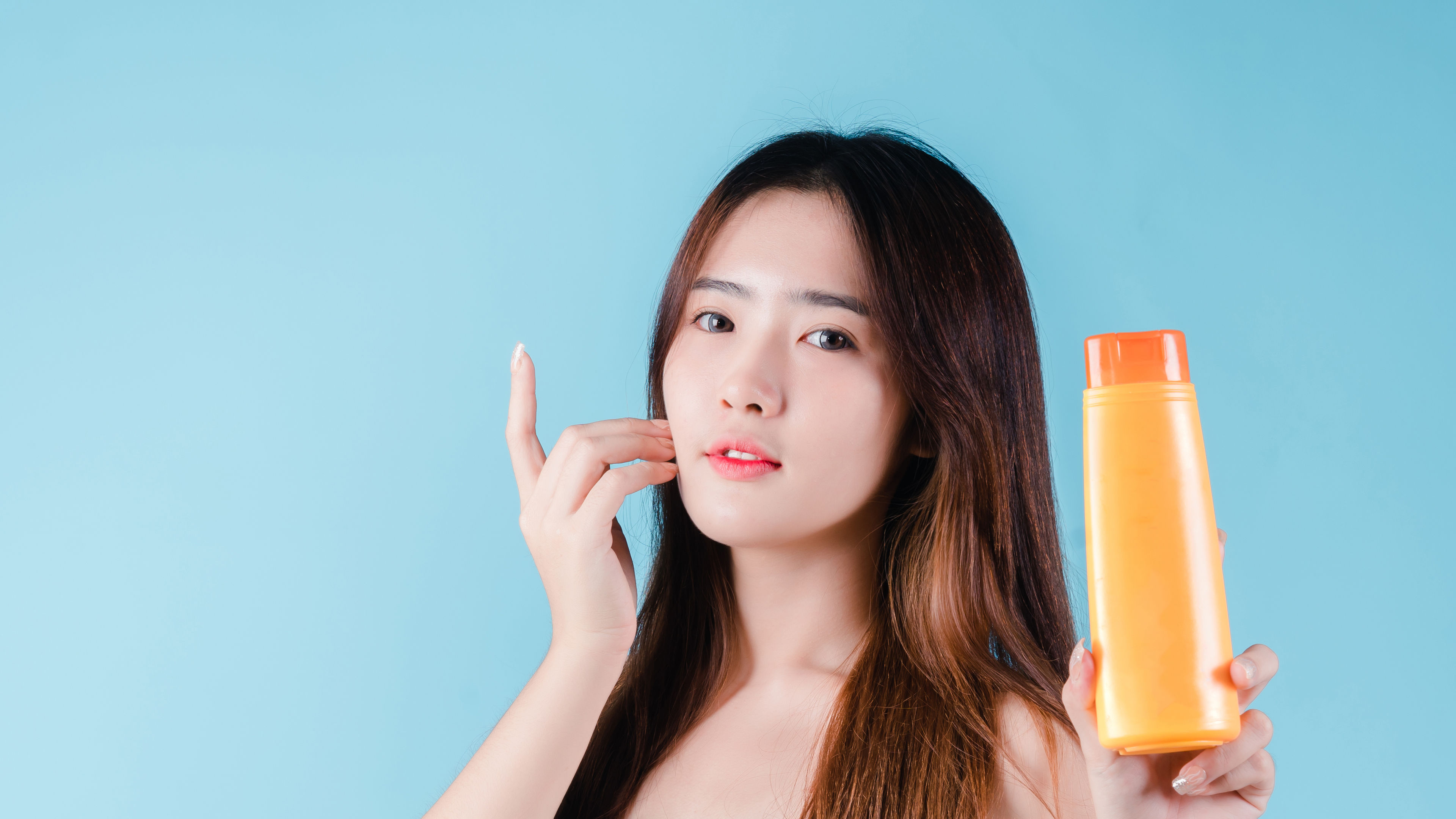 Young Woman Holds Orange Bottle