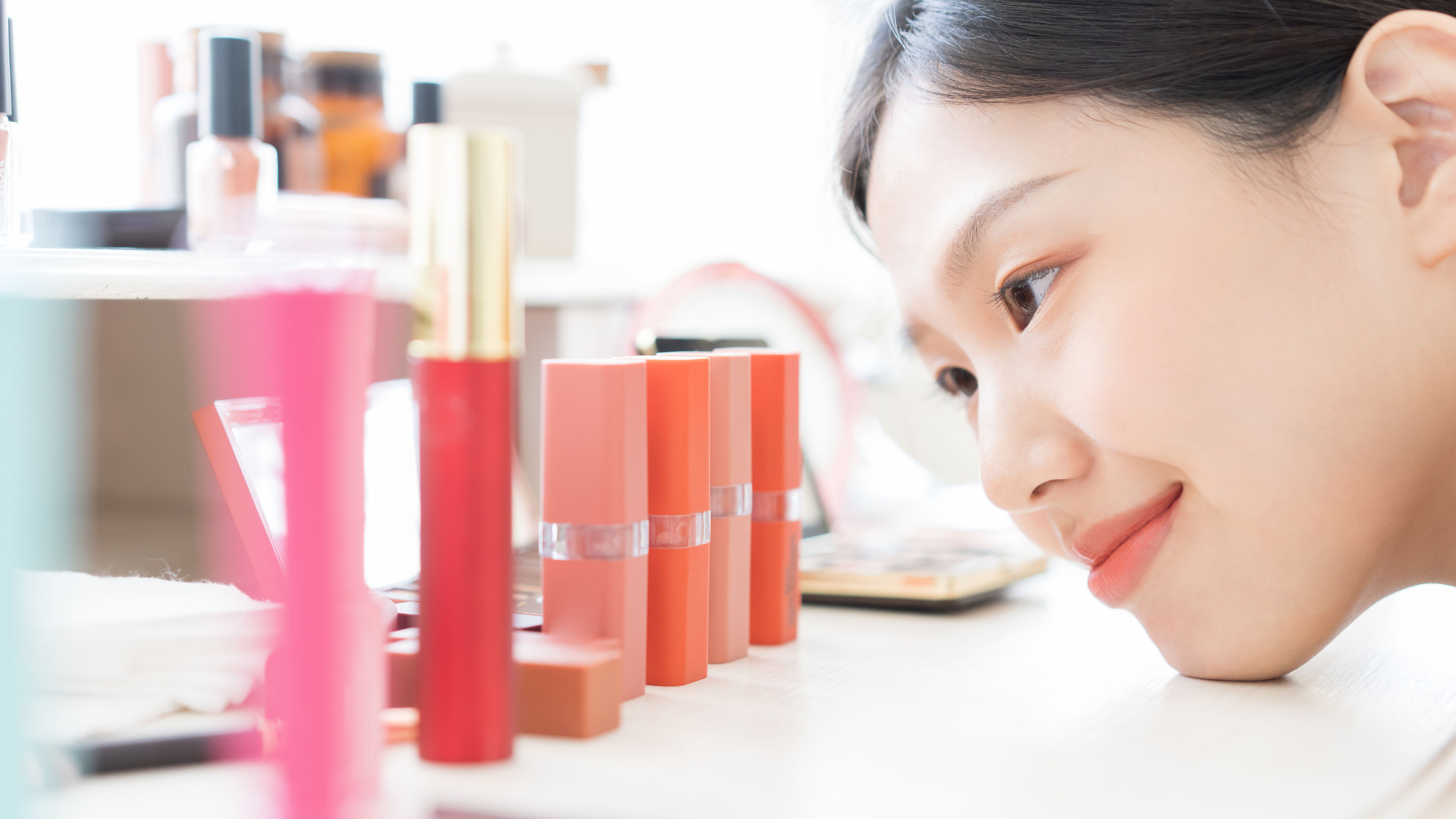 A women admiring beauty products on the table.