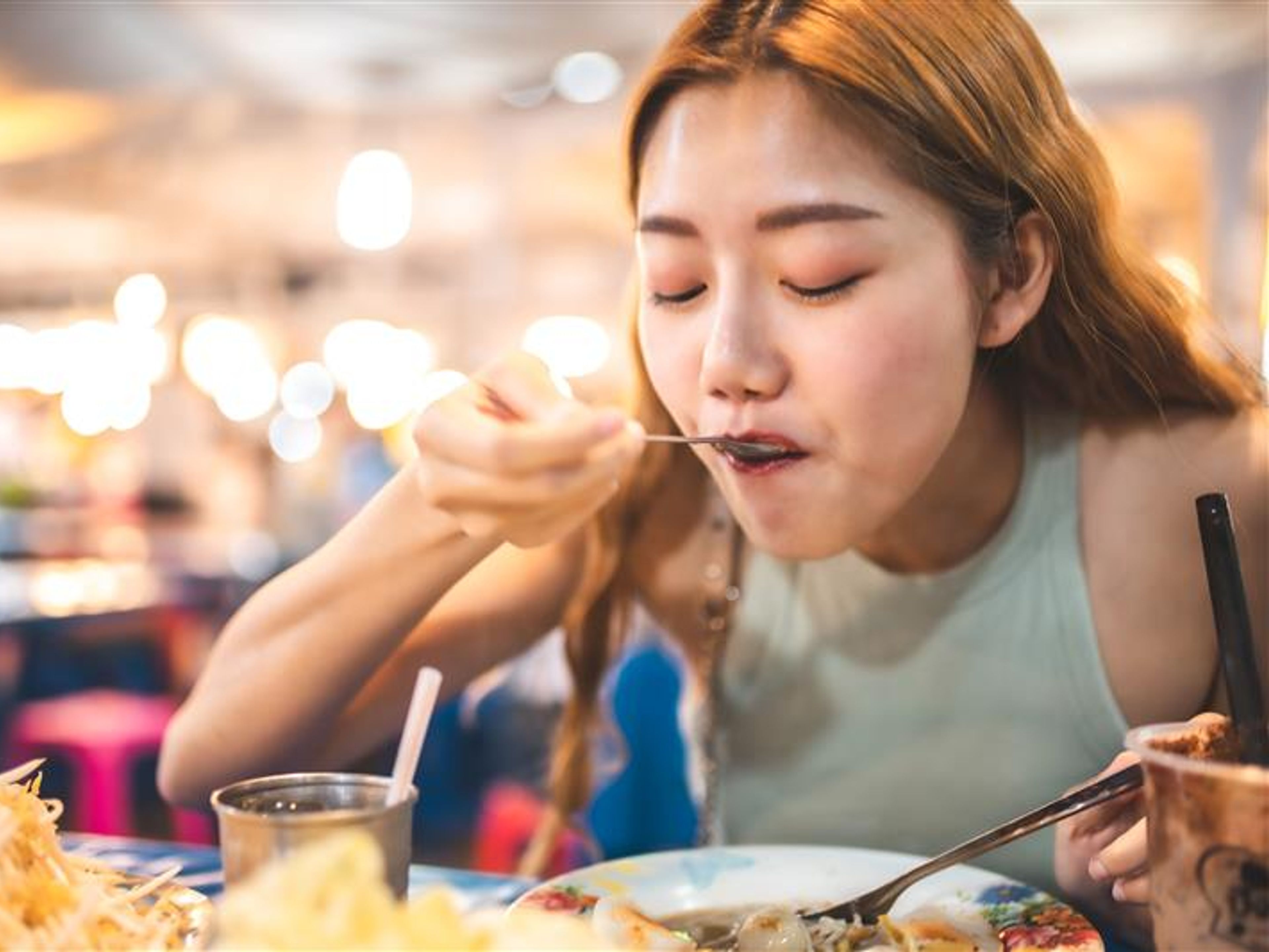 A woman tasting some food. 