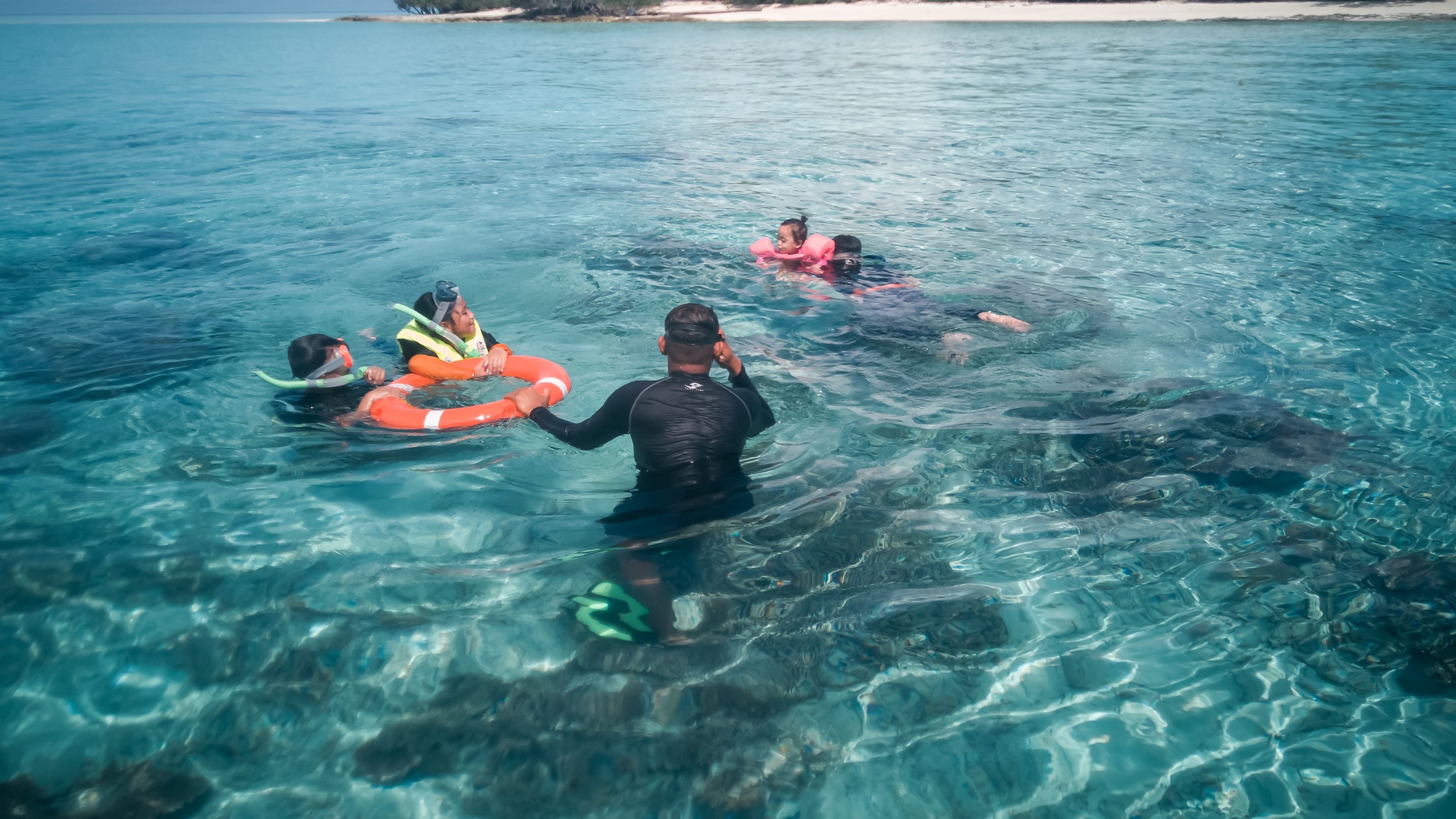 Sekumpulan pelancong snorkeling di perairan jernih