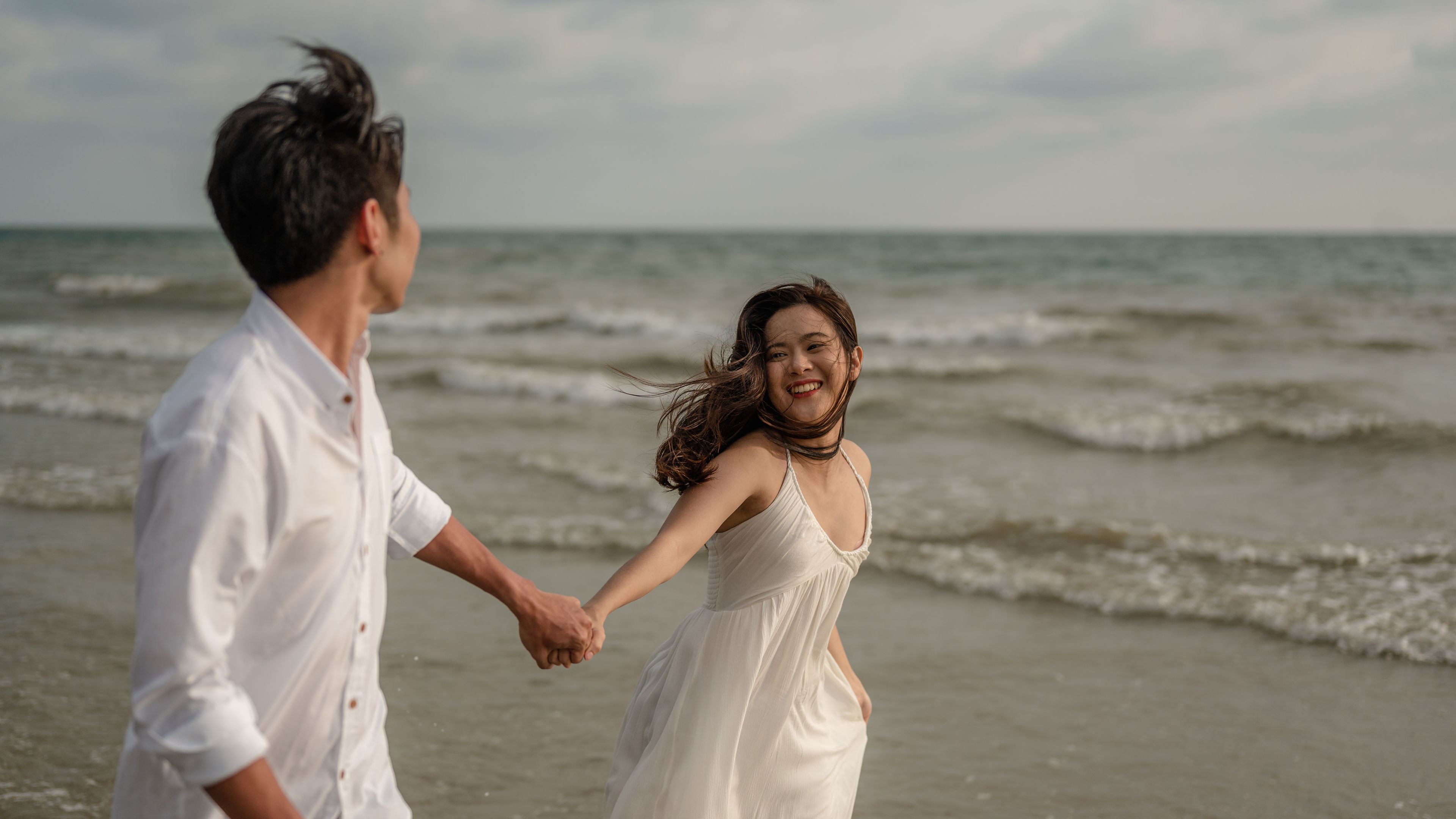 A happy couple enjoys a relaxing walk by the beach