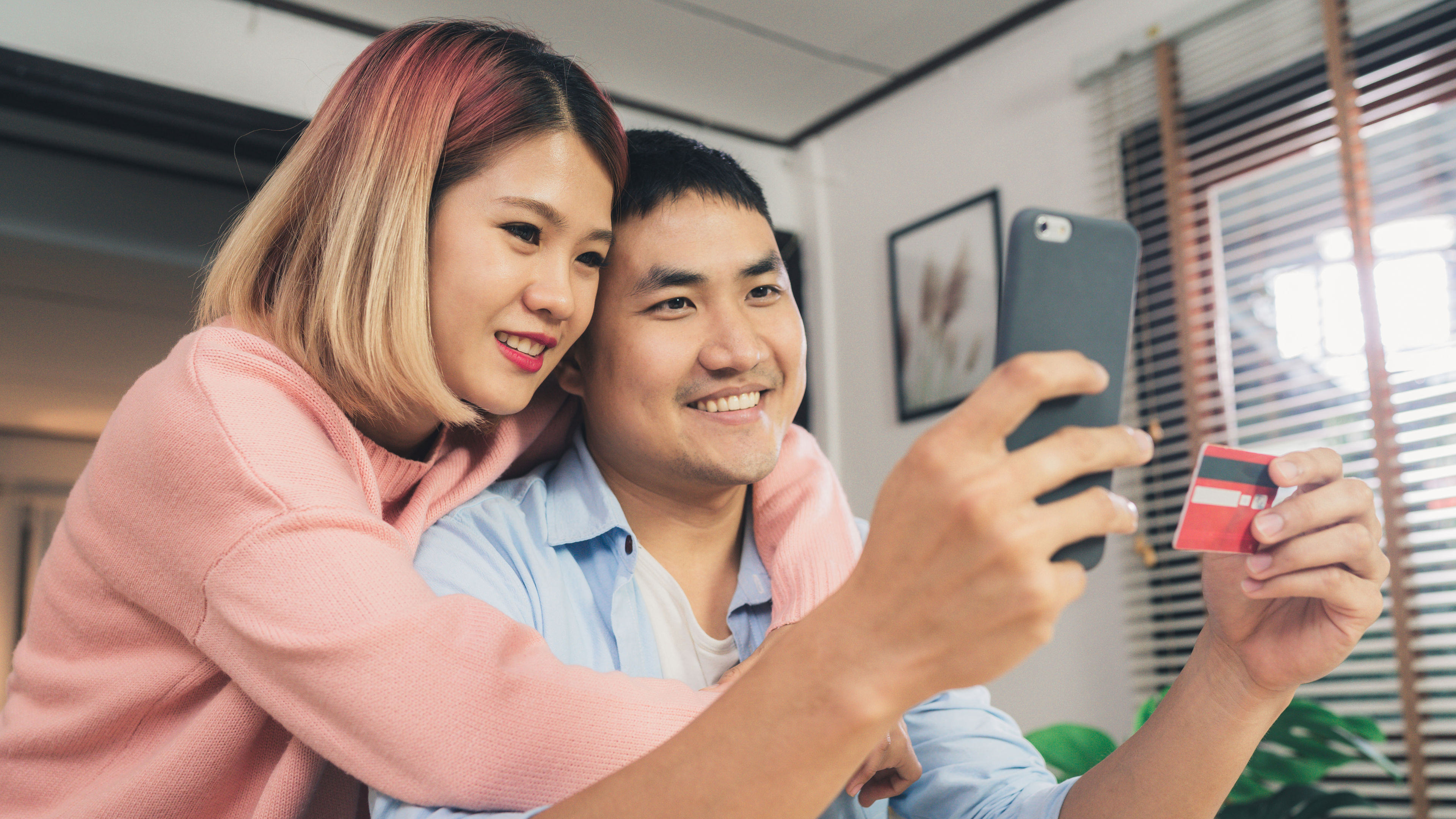Asian family couple using smartphone discussing news or doing online shopping