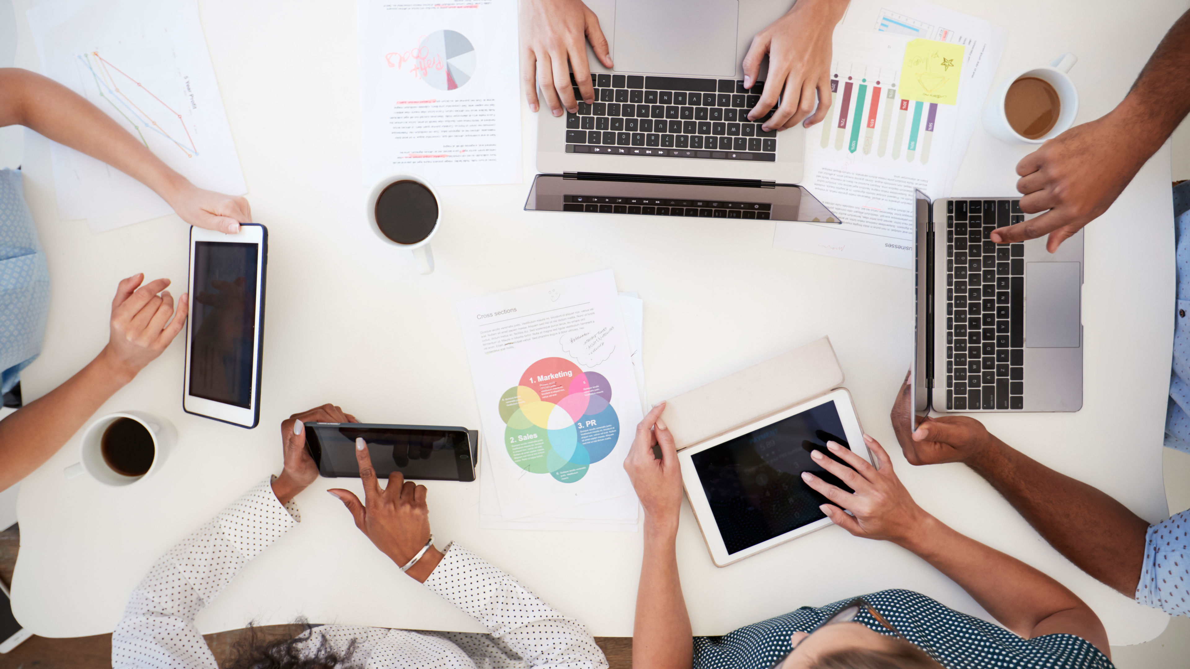 Business people using computers at a desk, overhead shot