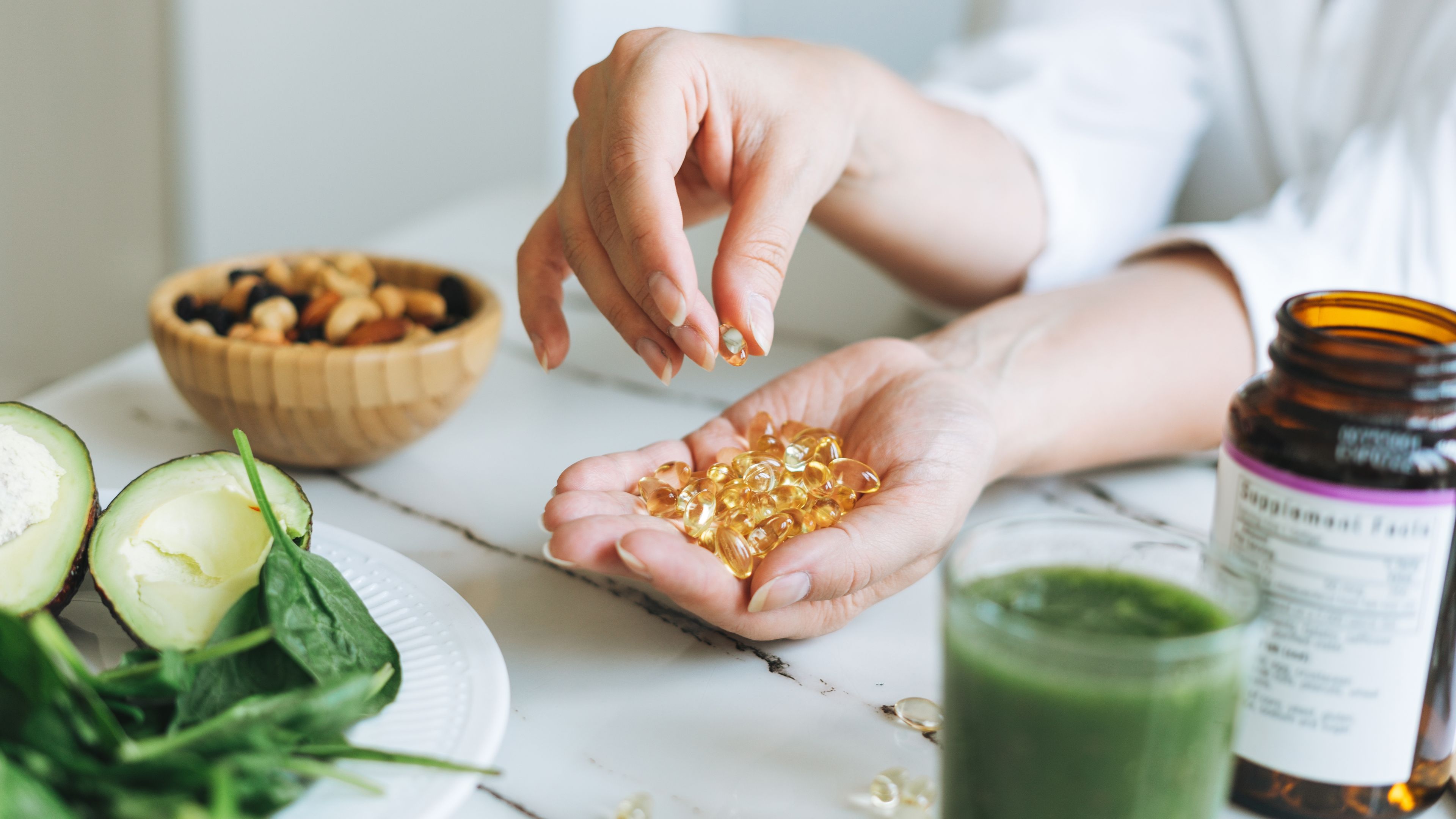 Female hands with omega 3, vitamin D capsules