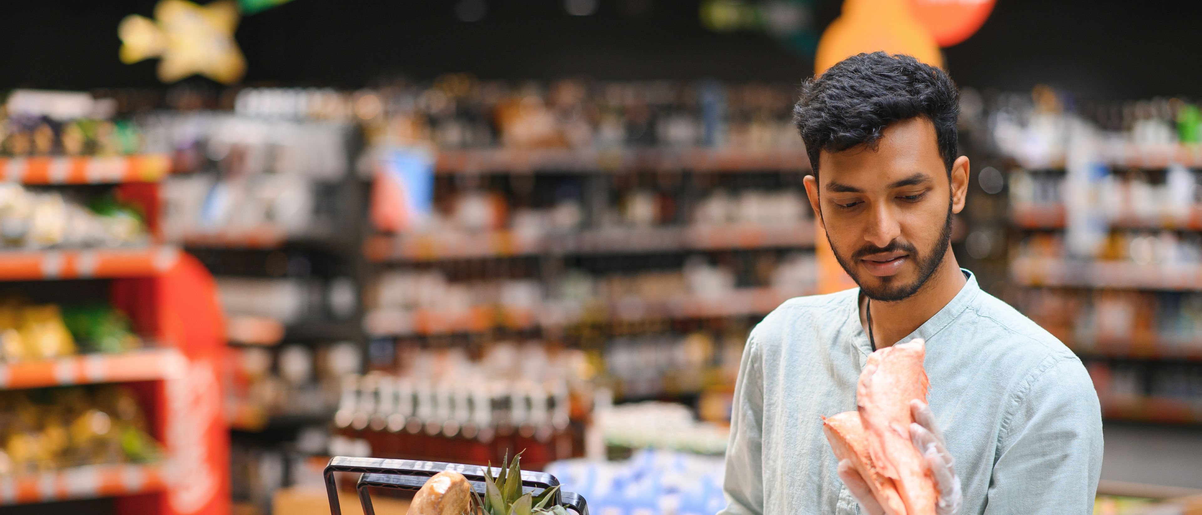 Young man buying meat from shop