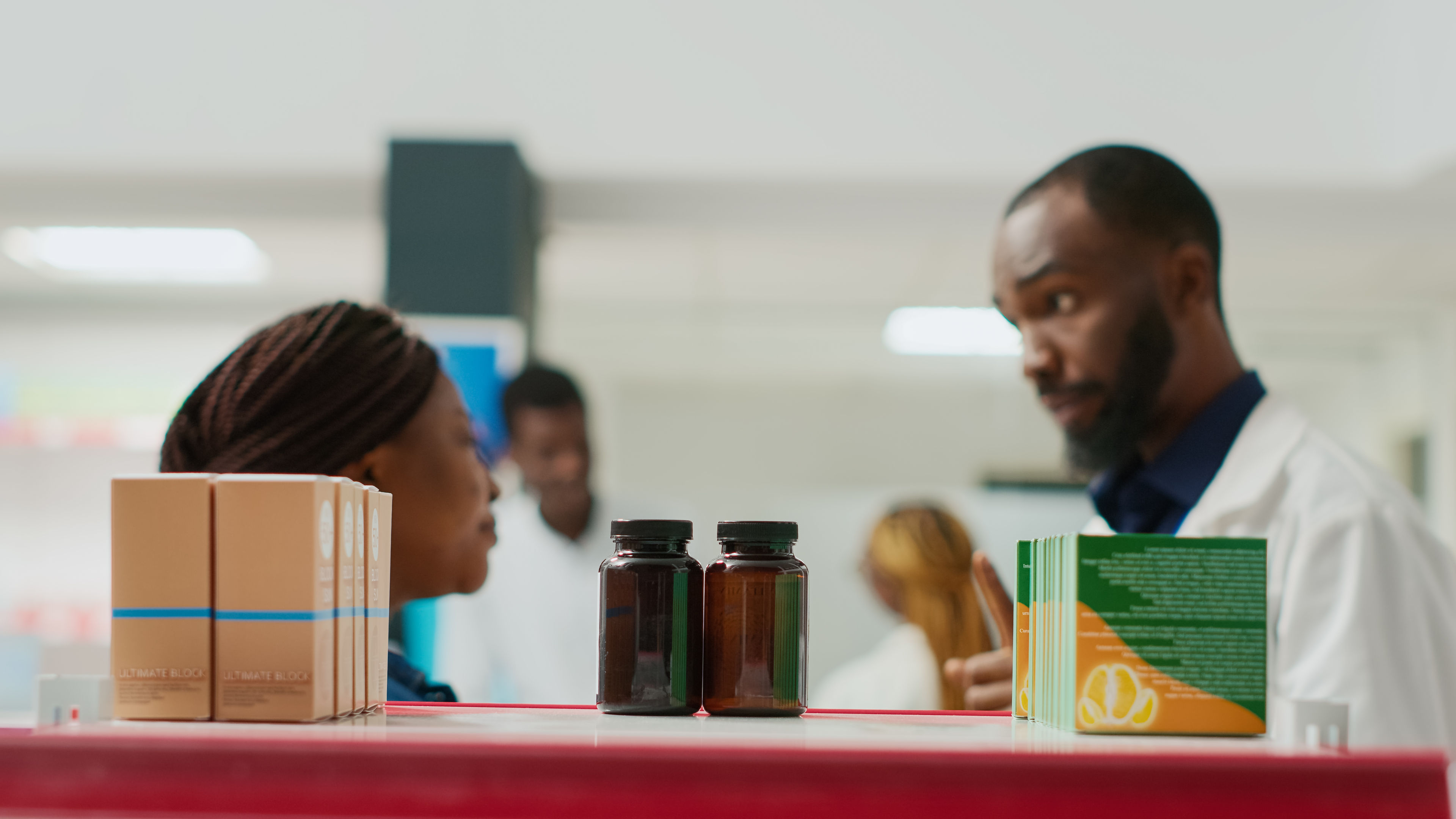 African American consultant giving box of pills to woman.