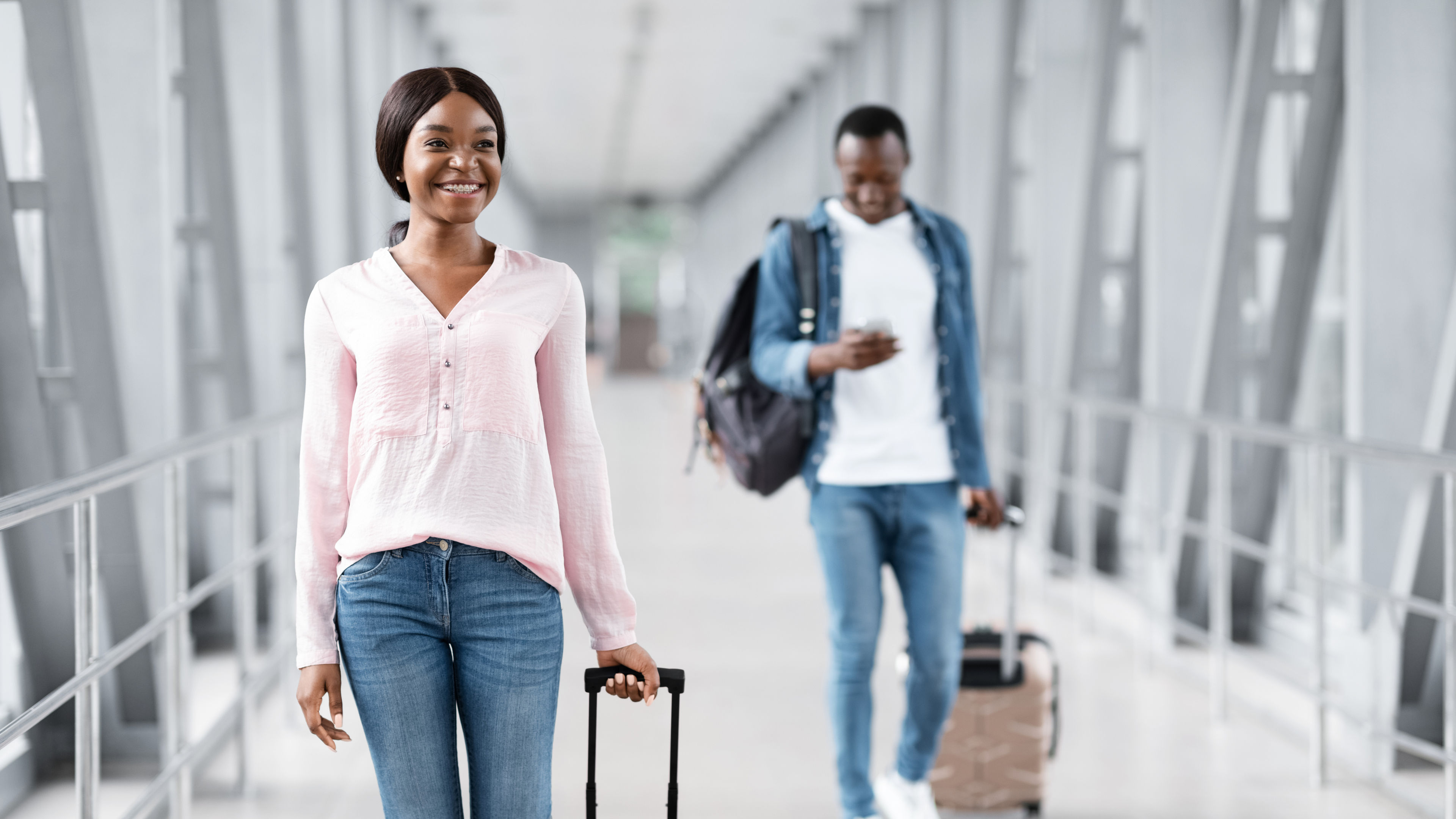 Cheerful Black People Walking With Luggage In Airport Terminal.