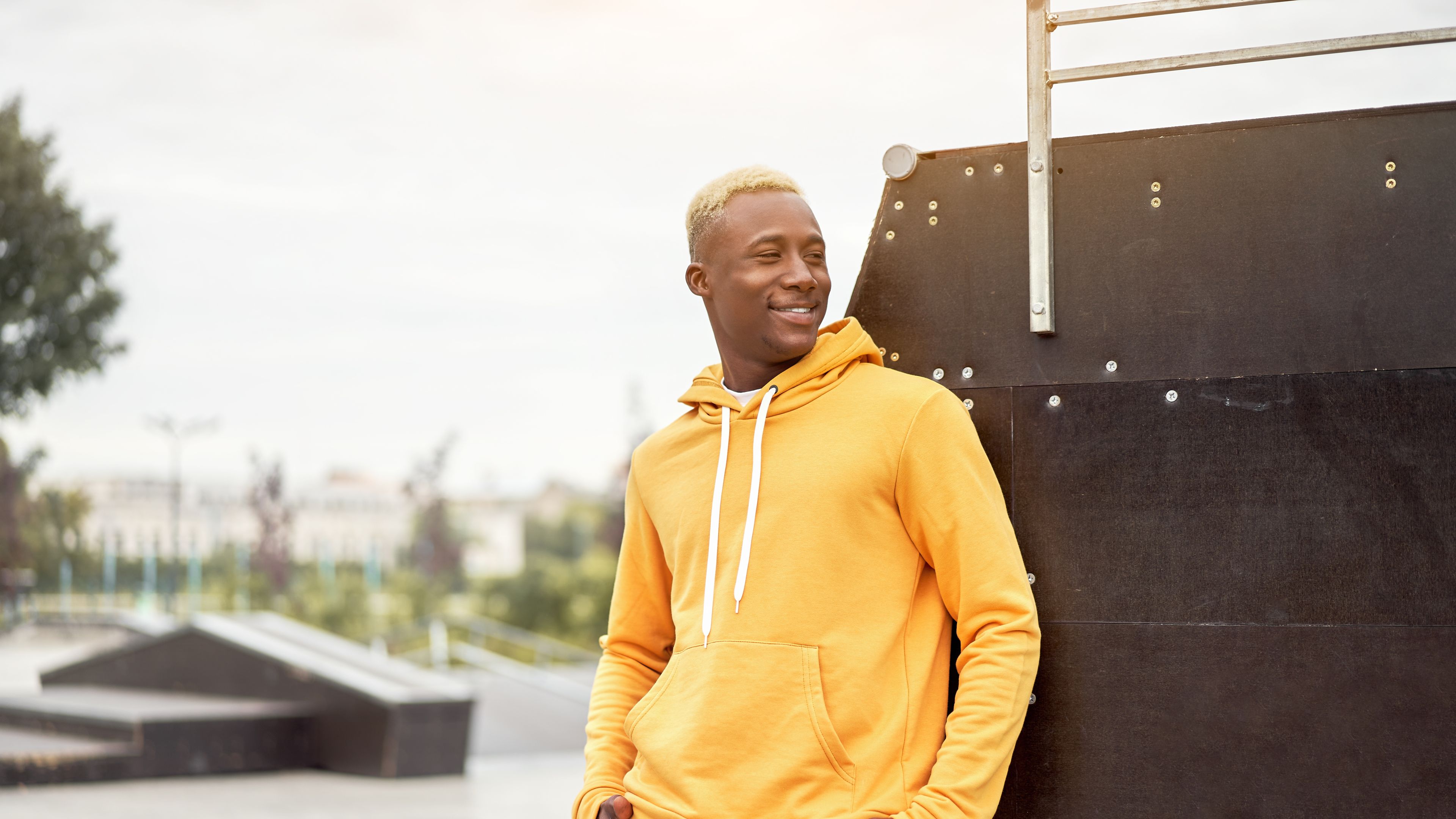 African young man smiling in a yellow hoodie