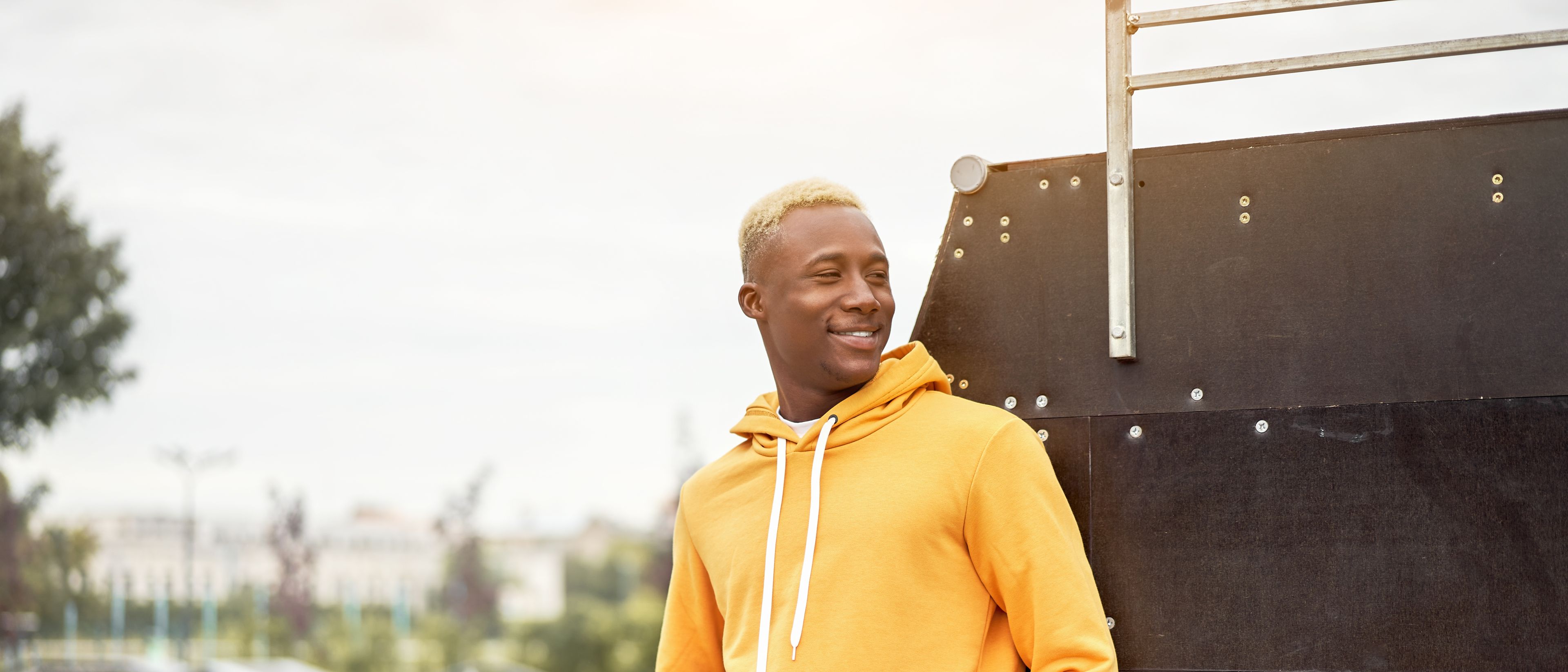 African young man smiling in a yellow hoodie