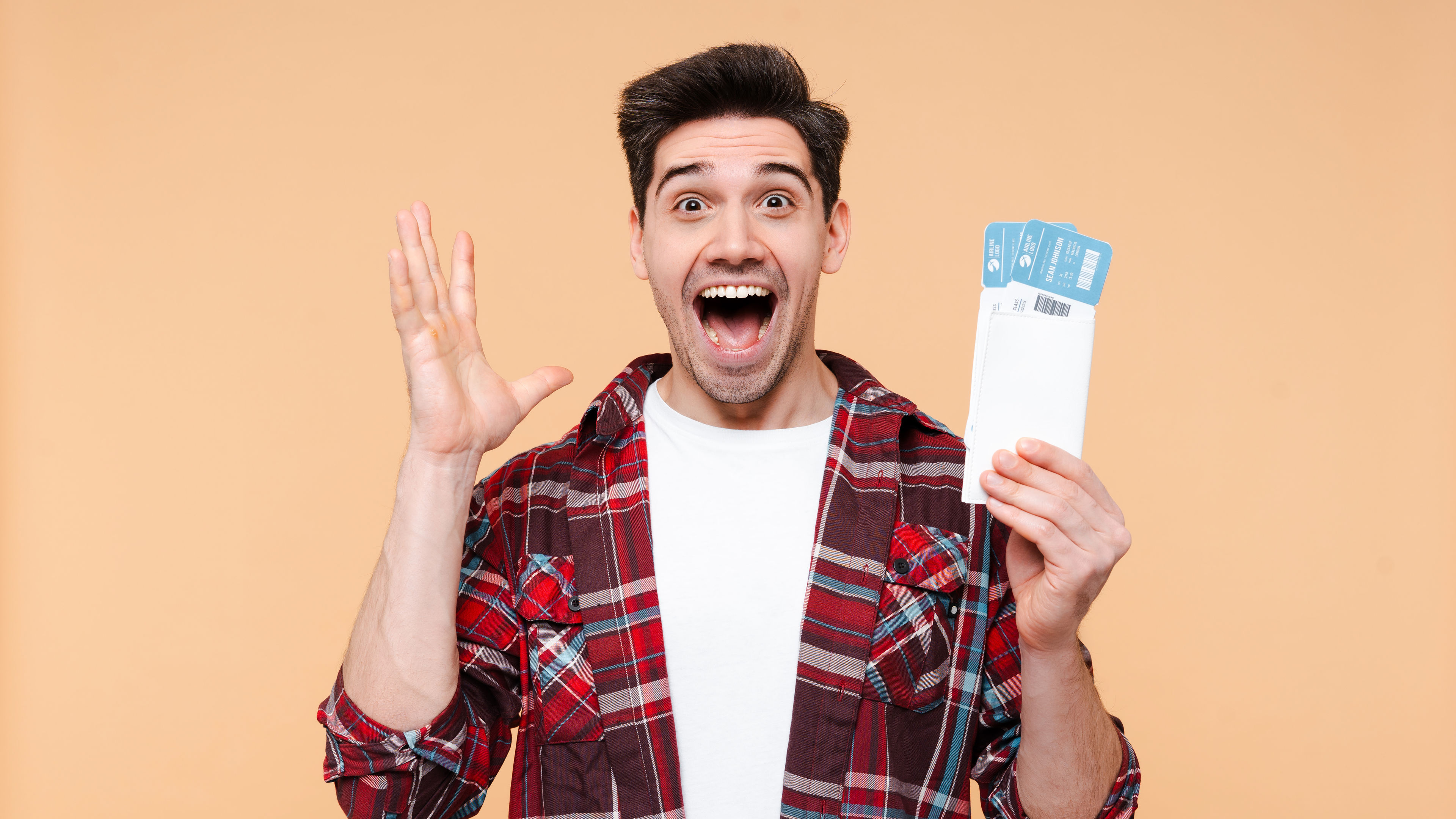 Excited man holding airline tickets for trip.