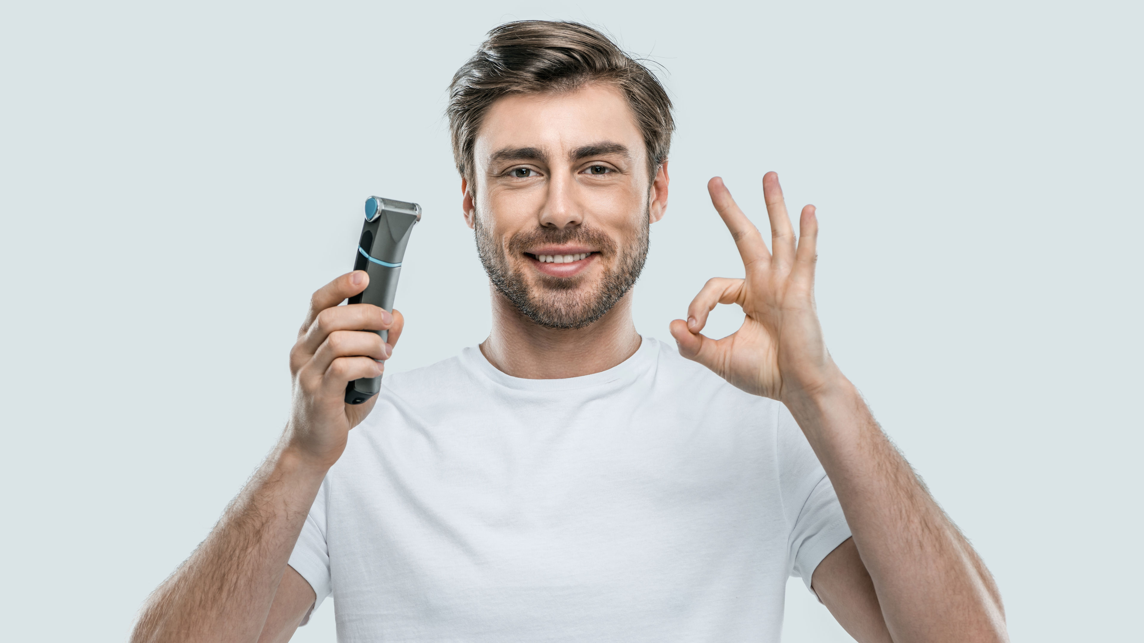 Man Holds Trimmer While Making Okay Hand Gesture