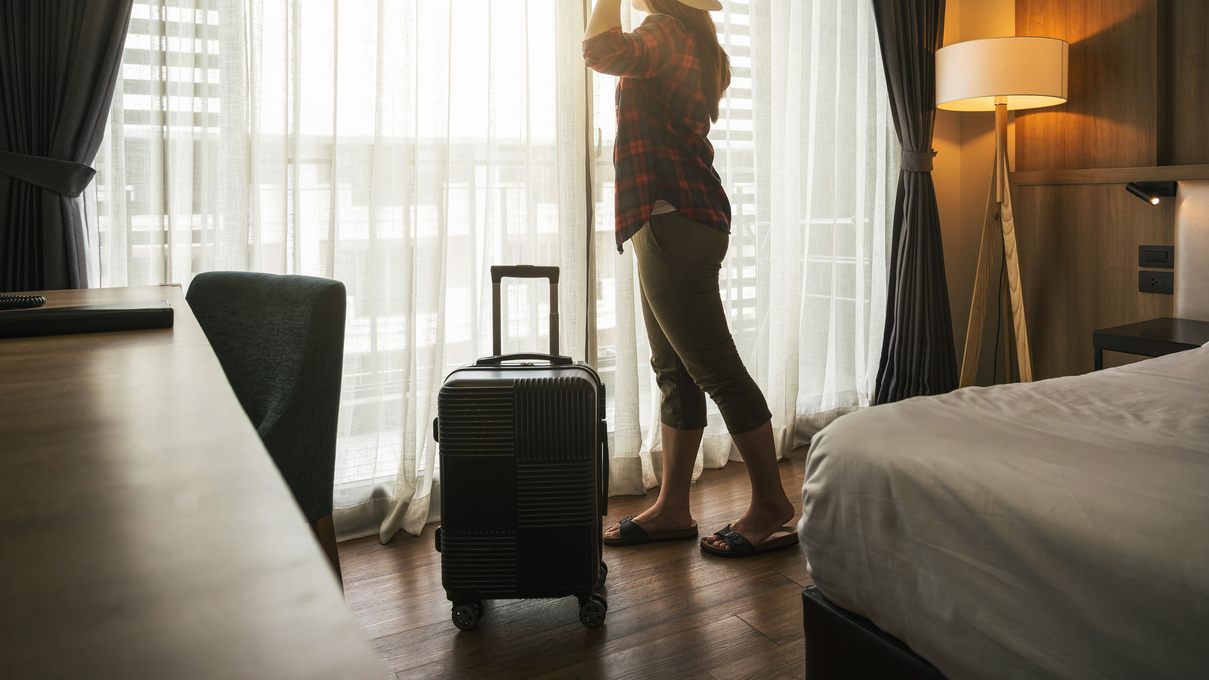 Happiness Asian traveler woman standing with baggage in bedroom of hotel