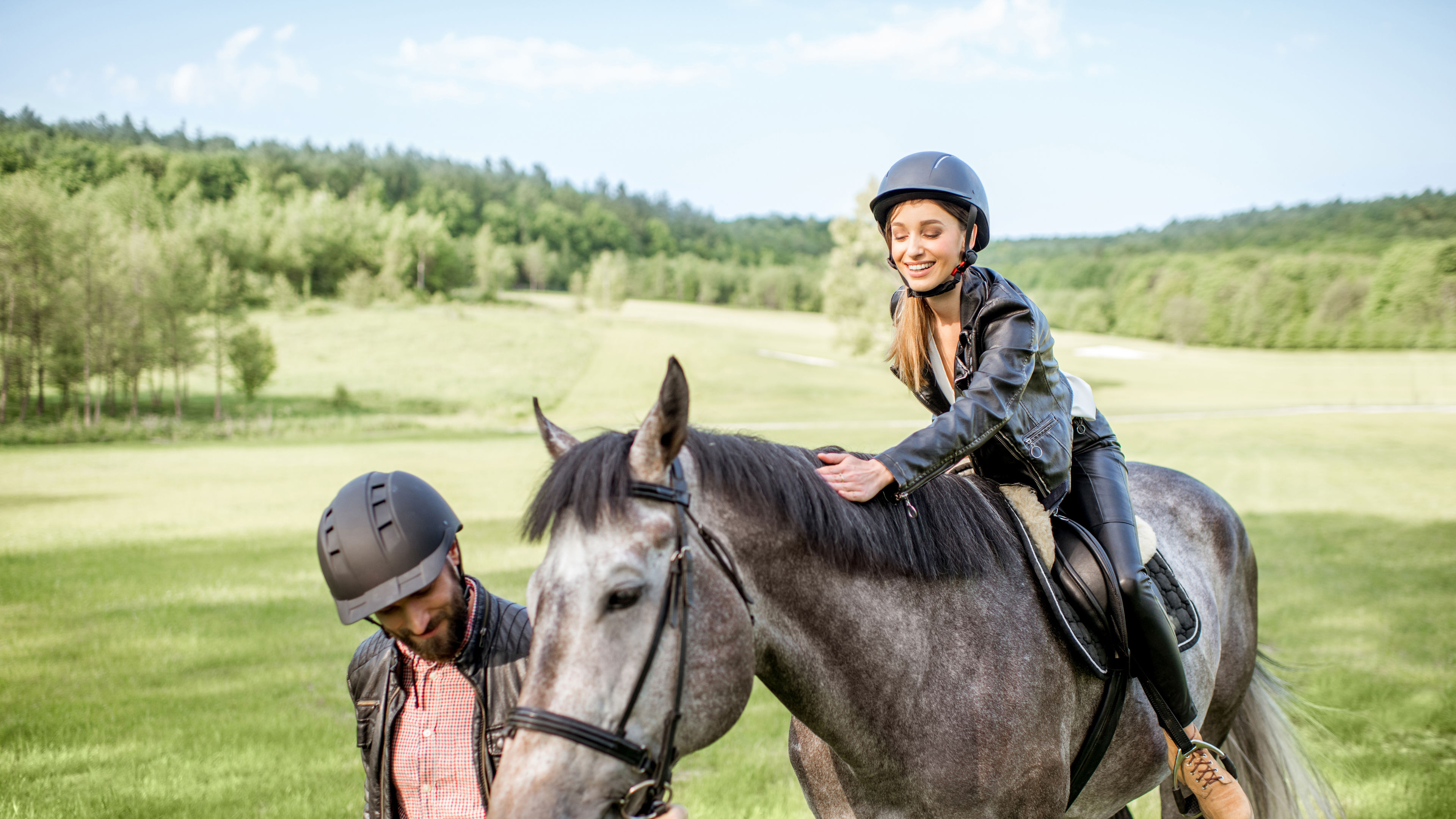 Couple riding a horse on the green field