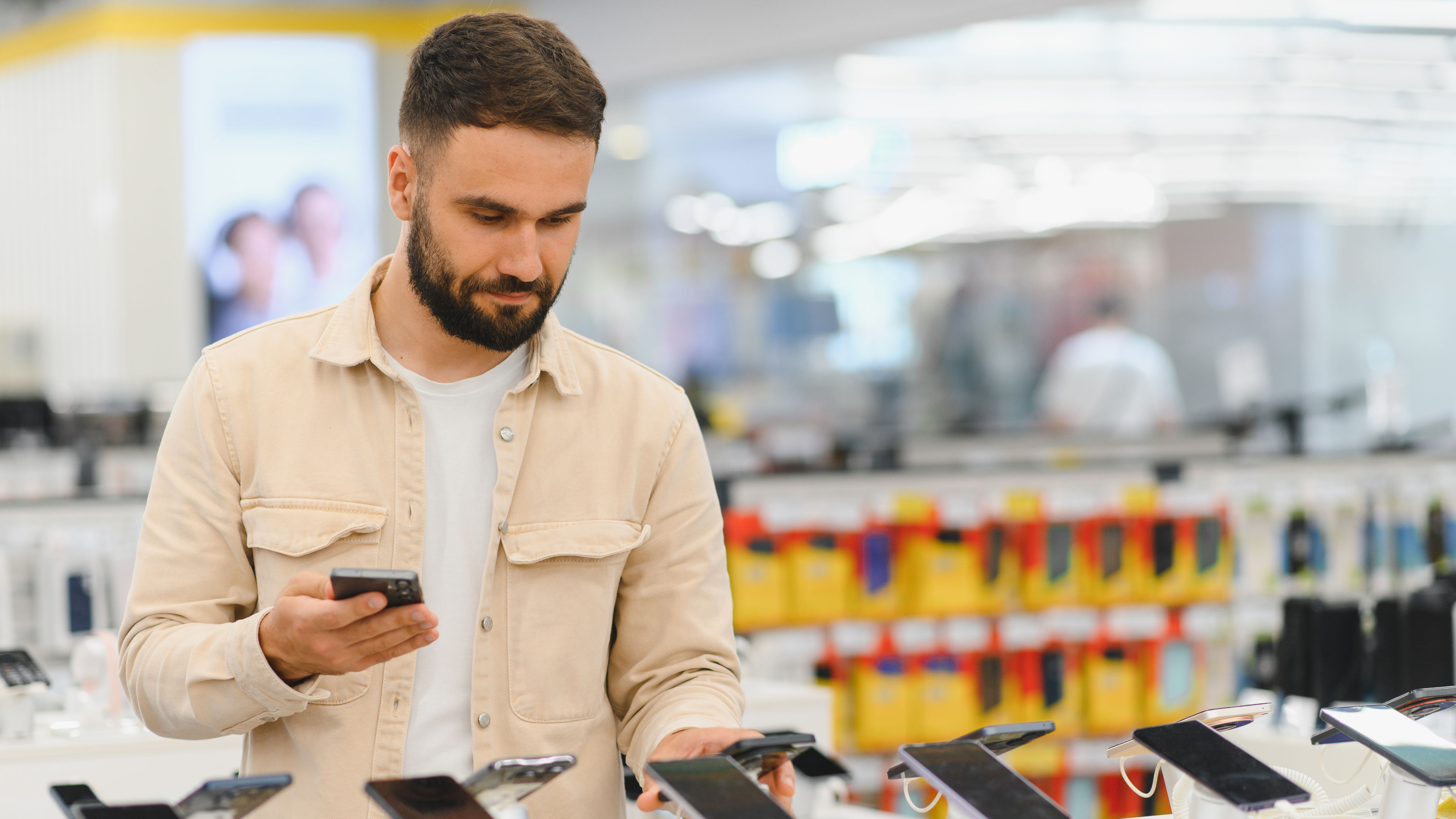 Customer comparing smartphones in electronics store