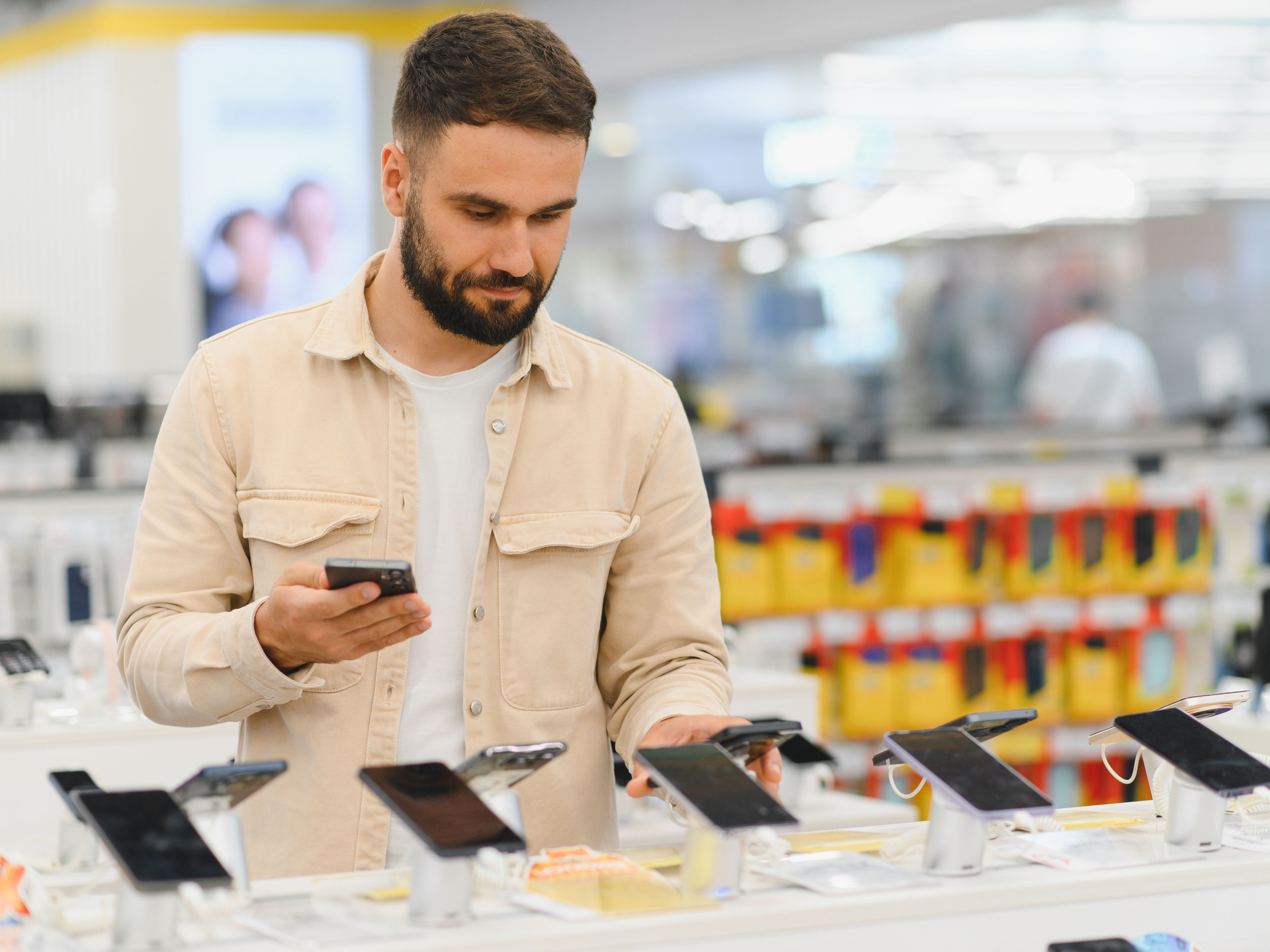 Customer comparing smartphones in electronics store 