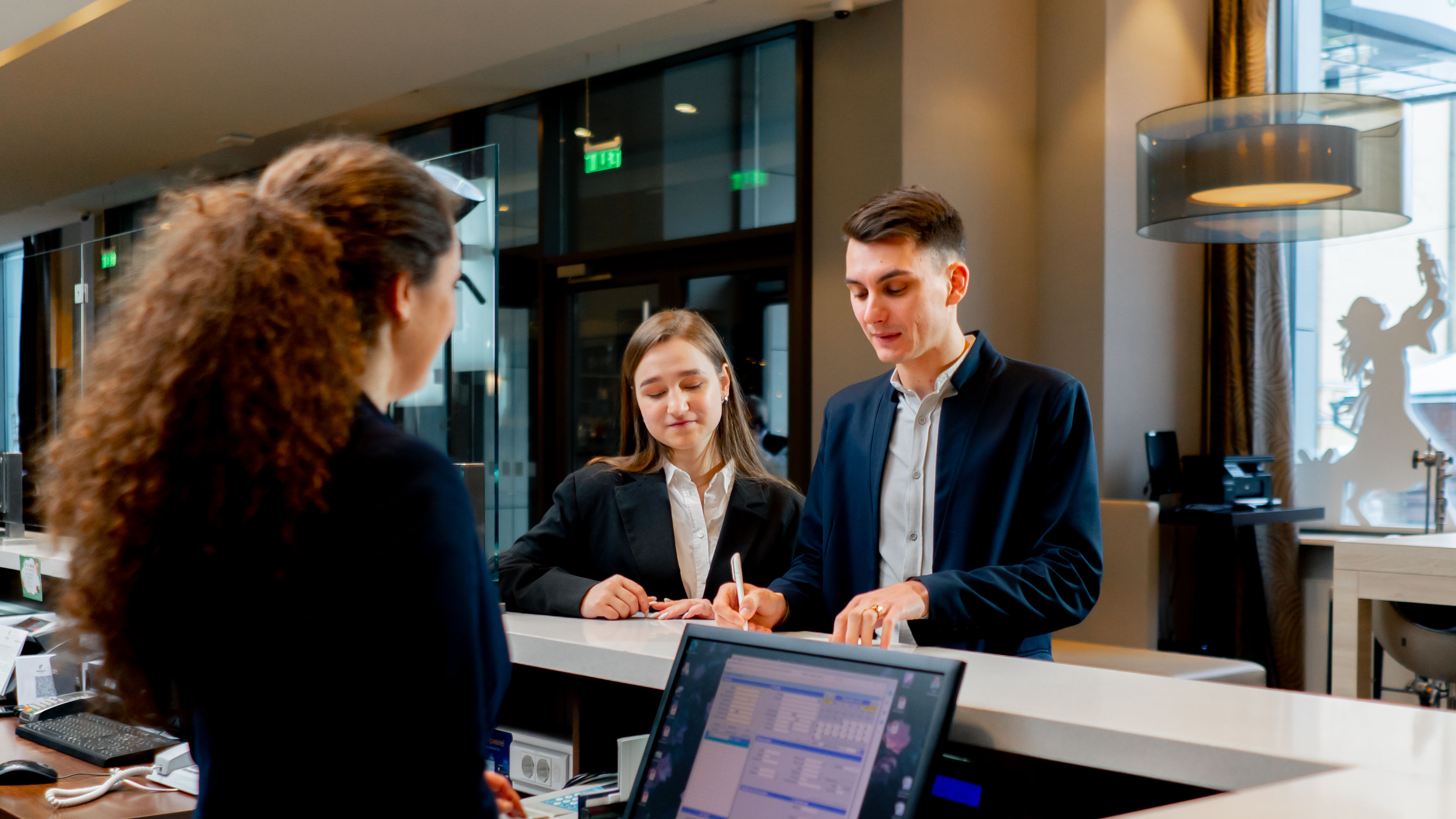 Two people at a hotel reception 